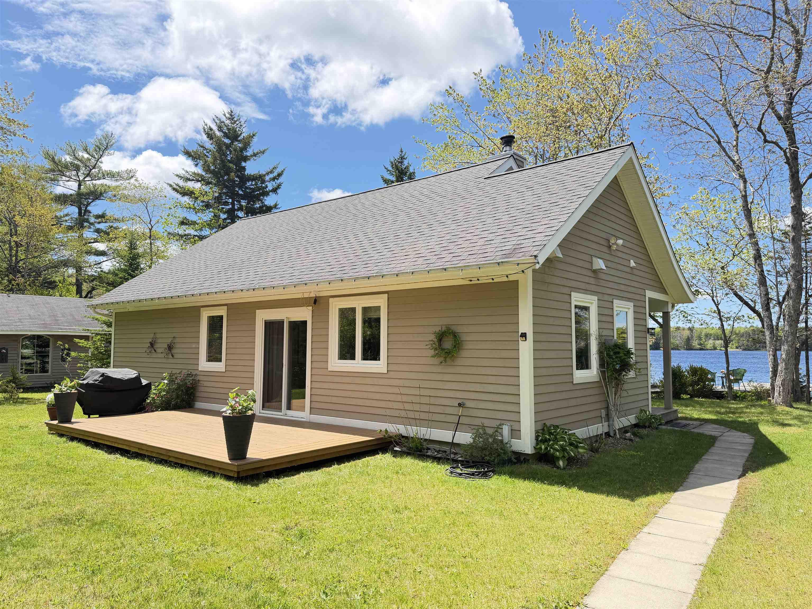 The property features a charming exterior with a covered front porch, a well-maintained lawn, and a winding wooden pathway leading to the entrance