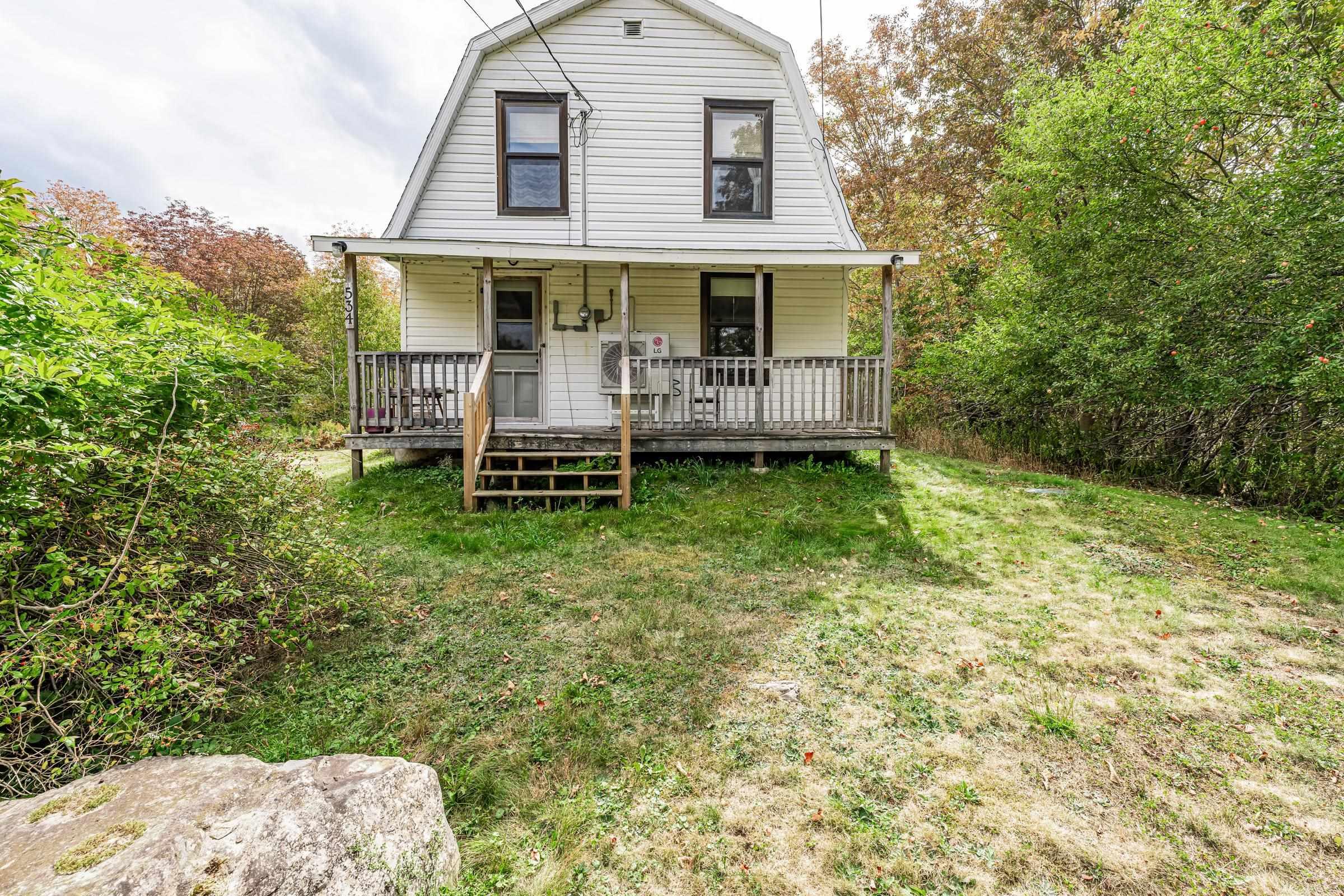 Dutch colonial featuring a gambrel roof, a front yard, and covered porch