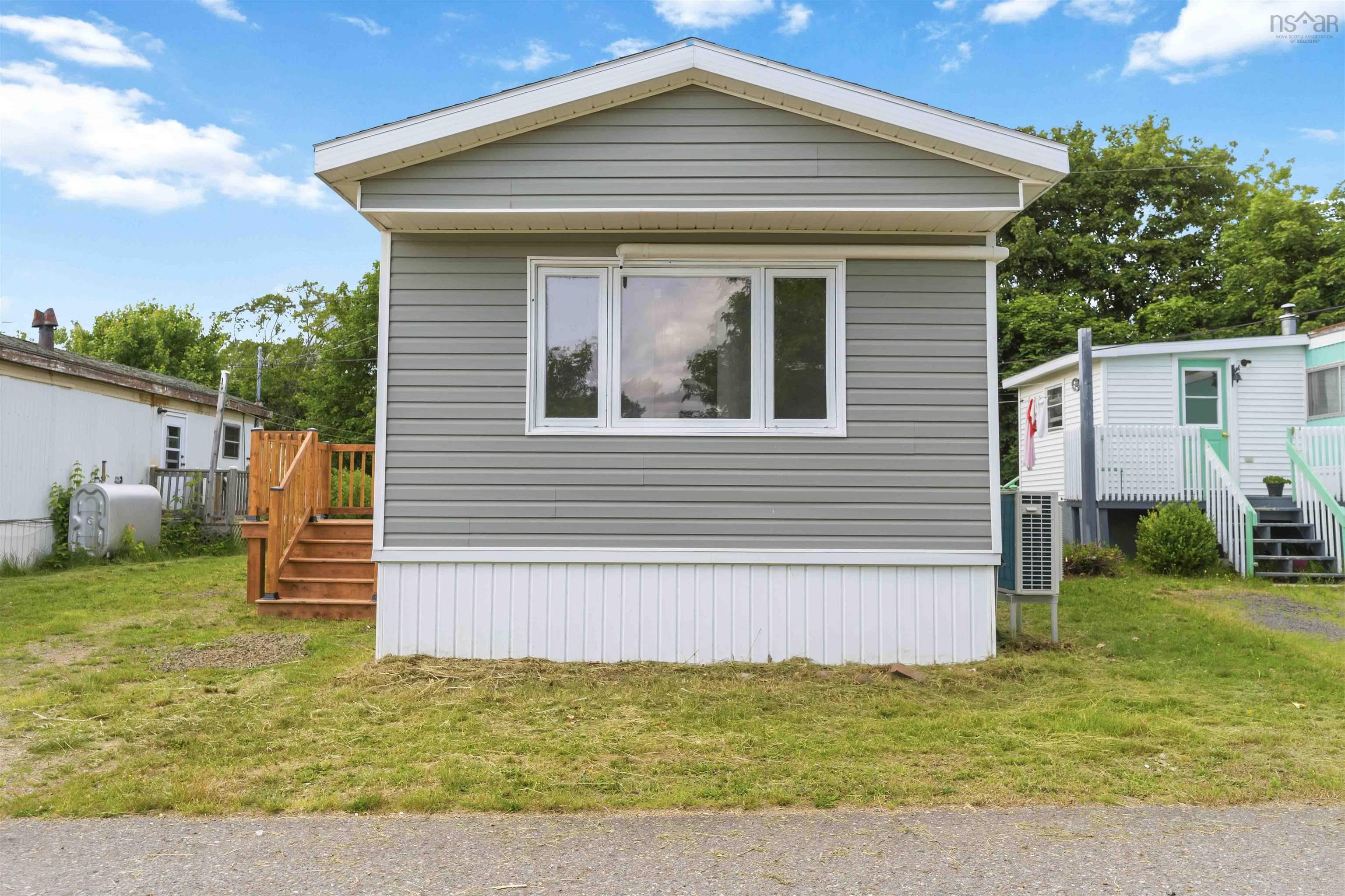 Gray horizontal siding exterior with white trim and a white foundation skirt