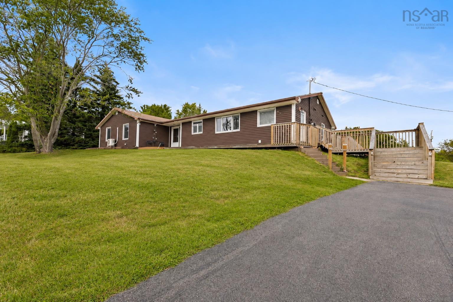 Brown exterior siding with white trim, featuring a paved driveway and a multi-level wooden deck