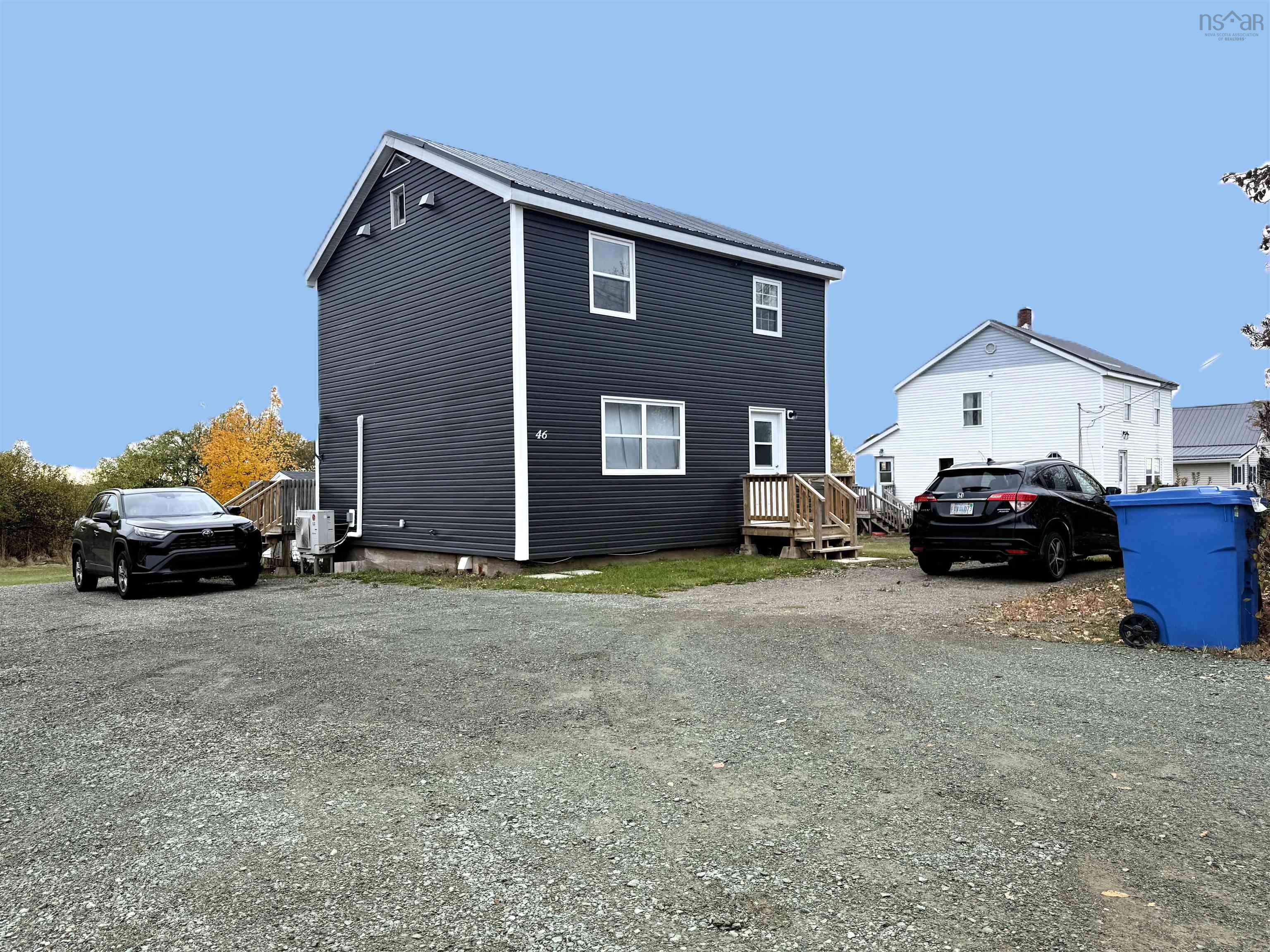 View of side of home featuring gravel driveway