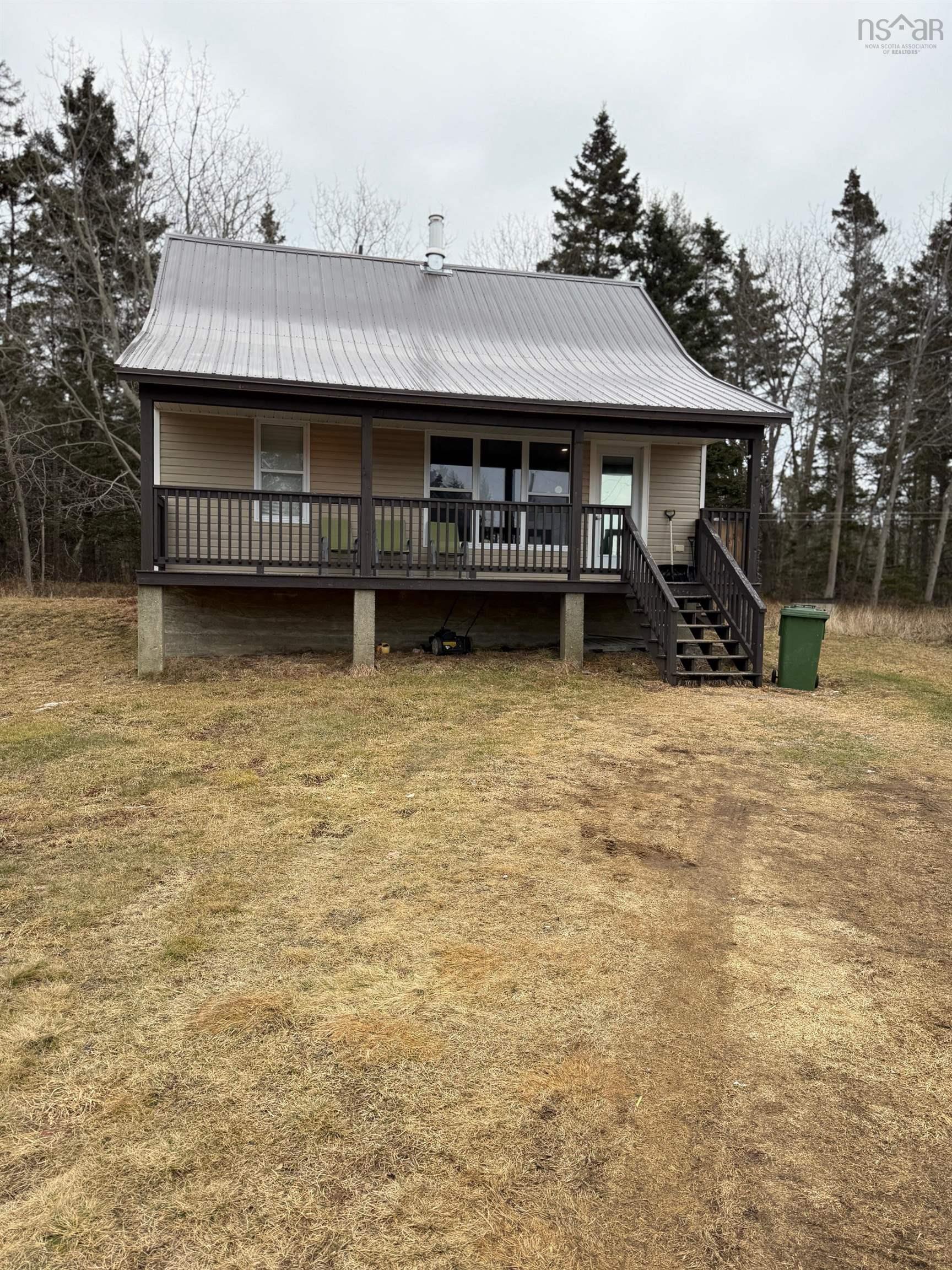 Farmhouse-style home with covered porch and a metal roof