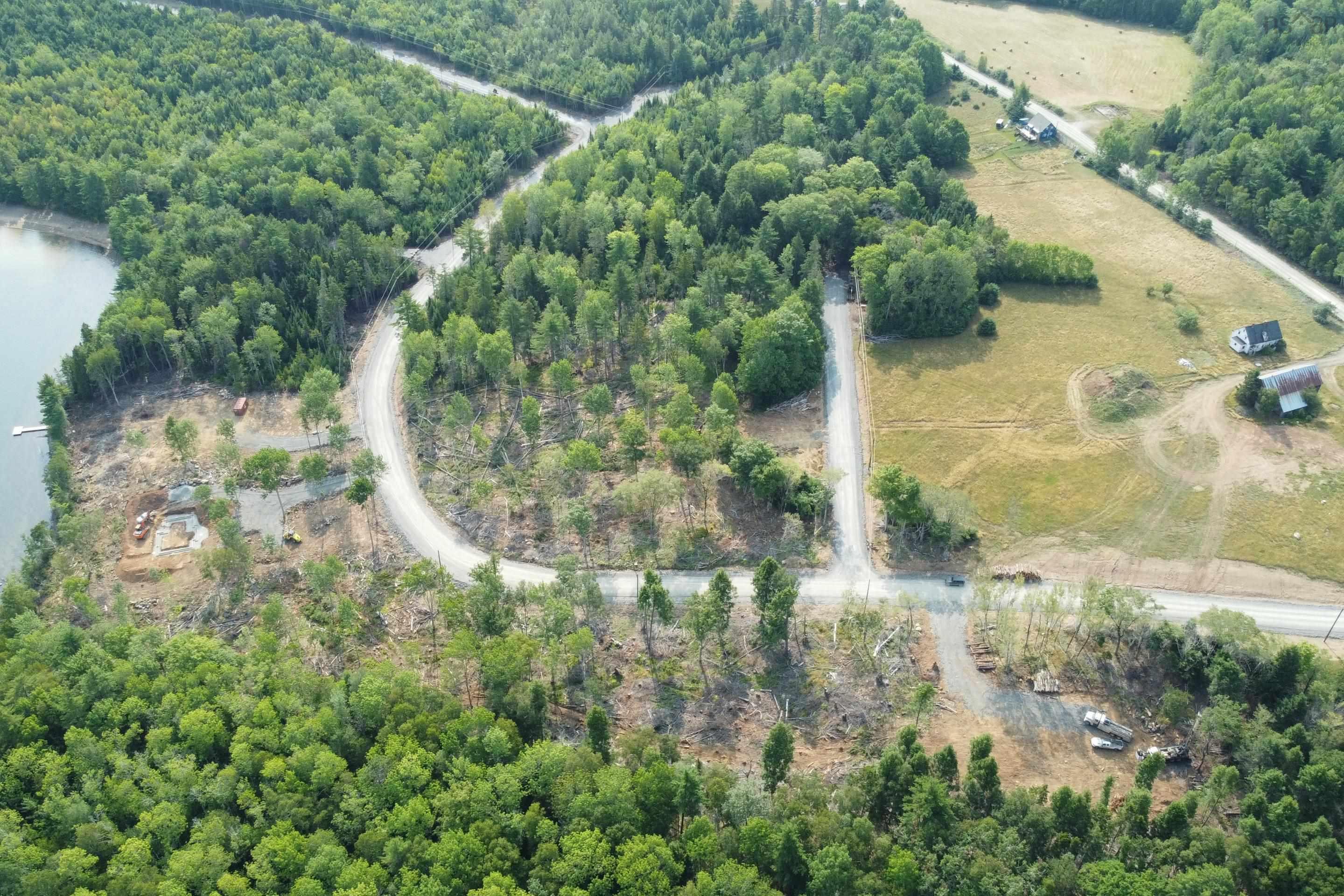 Aerial view of property and surrounding area with rural landscape and a heavily wooded area