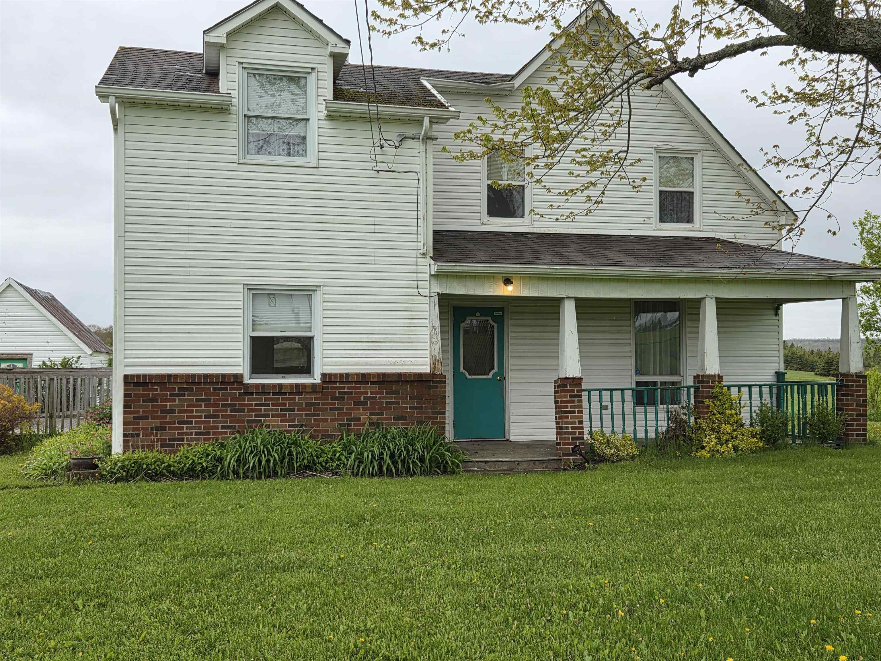 The property features a white exterior, a brown roof, and multiple windows