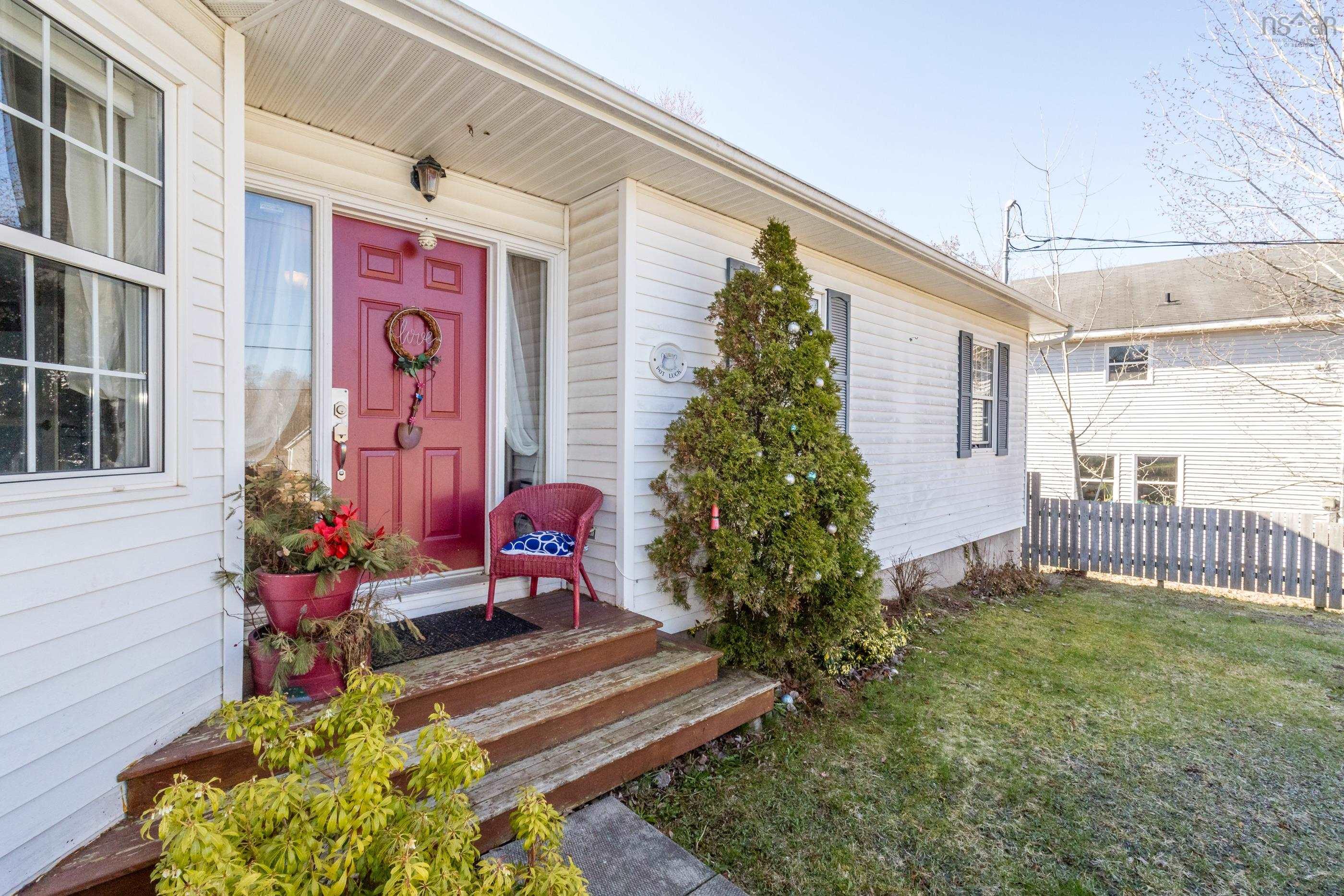 Exterior featuring white siding, a red paneled front door, white-framed windows, and wooden steps