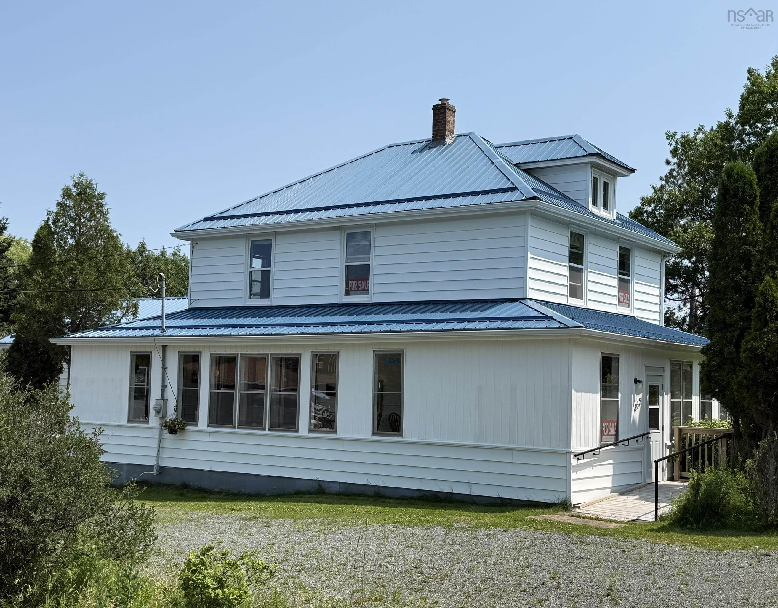 White siding exterior with a bright blue metal roof