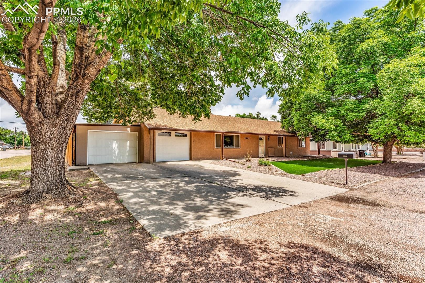 View of front facade featuring stucco siding, concrete driveway, and a garage