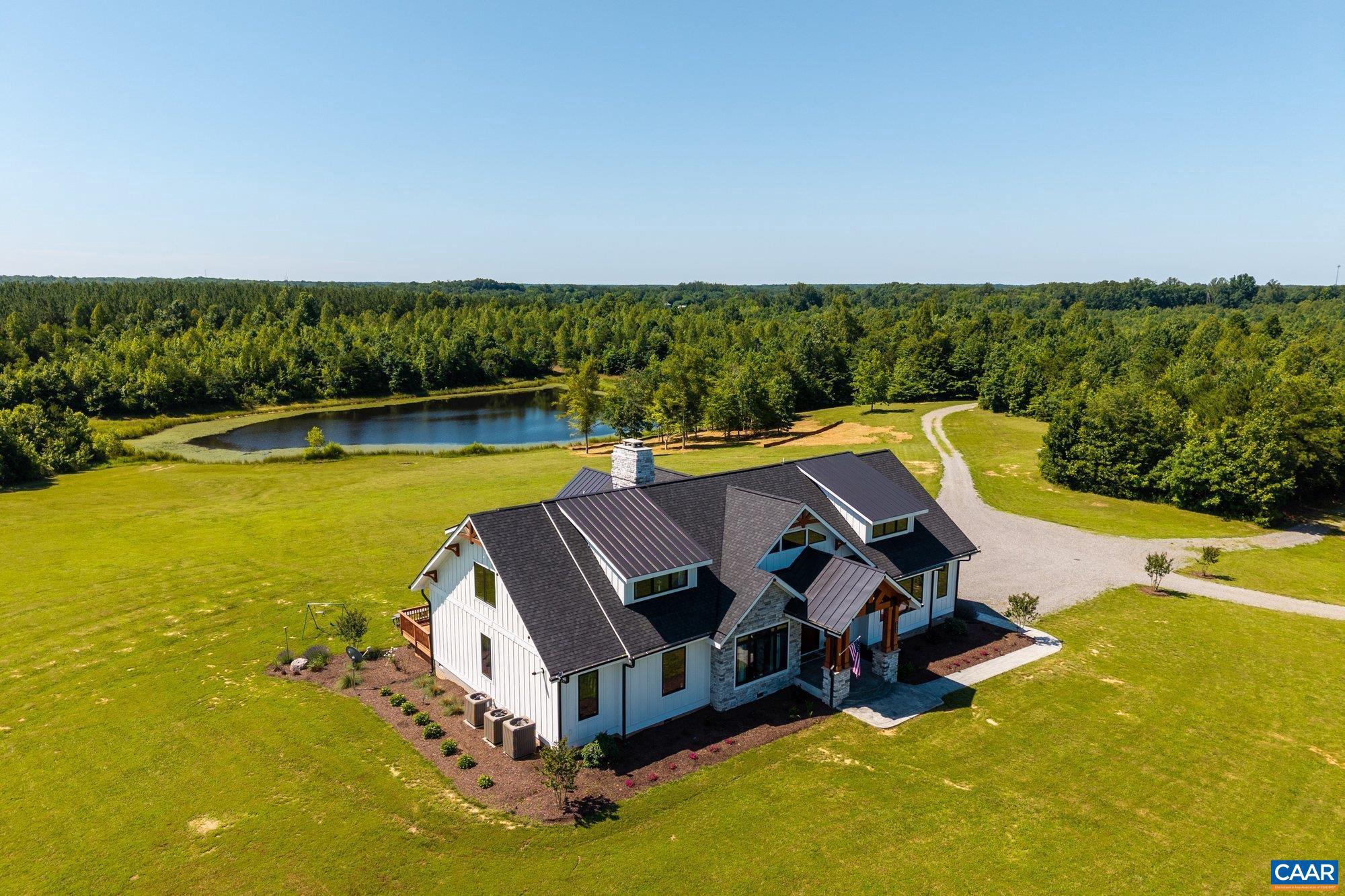 Welcome to Eagle Ridge?a refined country estate on 152 acres of rolling pasture, mature hardwoods, and 82 acres of 20-year-old loblolly pines. This 4,500 sq ft custom home features 10' ceilings, solid hickory floors, 8' mahogany doors, and Pella casement windows. The kitchen offers Viking appliances, a double-height 11' island, and level 7 Monaco quartzite. The main-level primary suite includes a spa bath with an 8' x 5' zero-entry shower, double rain heads, and full-height tile. A second main-floor bedroom with an 18' ceiling and four upstairs bedrooms provide flexibility. The great room stuns with a full-height stone fireplace, a custom burled redwood mantle, timber trusses, and cedar plank ceilings. Built with HardiPlank board-and-batten siding, Douglas fir beams, and extensive insulation, the home has a fully conditioned crawl and attic. Outdoors: 1,300+ sq ft of stamped concrete porches, 3 stocked ponds, riding trails, and a 4,200 sq ft barn with secure storage.