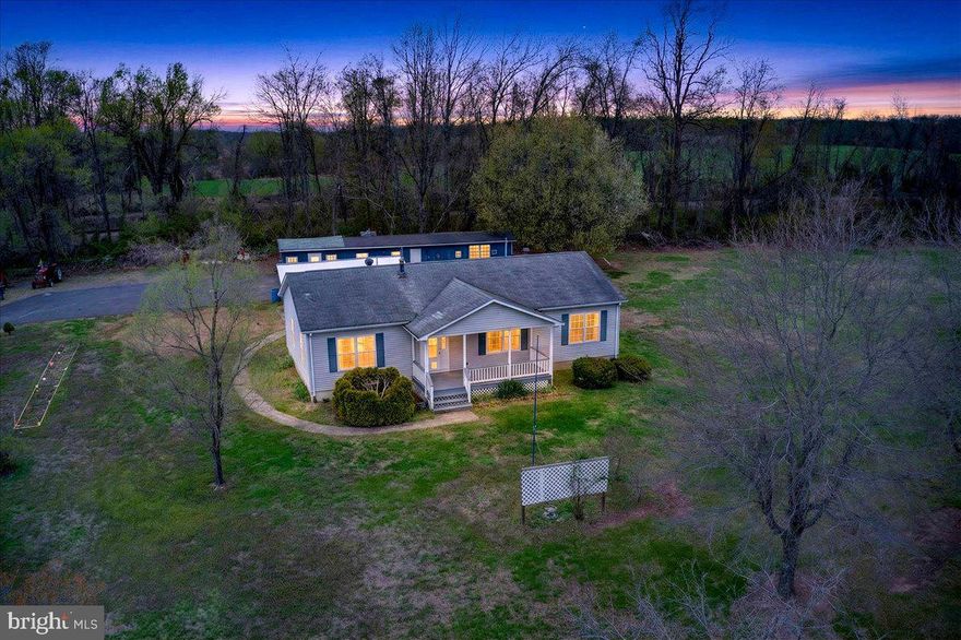 Set on over eight acres just moments from the Rapidan River, this three-bedroom, two-bath home offers a rare opportunity to own usable land, functional space, and long-term potential in a peaceful rural setting.

The home features a practical and comfortable layout with generously sized living areas and abundant natural light throughout. The main living room offers a large, open space with  a freestanding pellet stove, creating both a cozy focal point and an efficient supplemental heat source.

The kitchen provides an expansive footprint with extensive cabinetry, ample counter space, and room for dining, making it ideal for everyday living or future customization. Just off the kitchen, additional living space offers flexibility for a second sitting area, office, or expanded entertaining space.

Bedrooms are well-sized and filled with natural light, offering simple, comfortable living with room to personalize over time.

Outdoor features set this property apart. A covered front porch provides a welcoming entry and a place to enjoy the surrounding landscape. The property includes multiple outbuildings, including large machine/shop spaces and additional structures suitable for storage, workshop use, or hobby space.

The land itself is open, usable, and offers a variety of possibilities—whether for recreation, work, or simply enjoying the privacy and space.

Located just minutes from the Rapidan River and within a reasonable distance to shopping and dining, this property offers a unique blend of rural living with accessibility and potential.