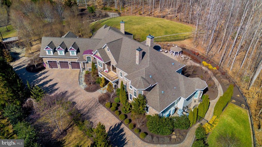 Imagine residing in a luxurious estate home, nestled on a sprawling 10+-acre property with serene water access and a private dock. This meticulously maintained estate features a gourmet kitchen outfitted with top-of-the-line Thermador appliances, including a steam oven. 5 spacious bedrooms, two on the main level and four with en-suites, office with large bay window built ins, coffered ceiling and plaid trim,  formal sitting and dining.   Enter through secured wrought iron gates into just under 3-acre fenced area with a 3-car garage.   This home ensures both comfort and convenience.  

The entertainment options in this home are exceptional. It features an INDOOR POOL on the main level, a two-lane regulation BOWLING ALLEY,  a THEATRE area, a second office/craft room with a painted concrete floor, ideal for creative projects, and a HOME GYM and a full bathroom in the lower level. The property is surrounded by extensive hardscaping with room for an outdoor kitchen area and landscaping within the fenced area.   Want to drop a kayak in the river?  Follow the meandering walkway through the natural wooded area which leads to a floating DOCK on secluded water frontage on the Occoquan River.  
The upper level features a large bonus area, perfect for a pool table, TV, or gaming areas.

The main floor is designed for accessibility, featuring ramp access from the garage, wider hallways, and an elevator providing easy access to all levels. Hardwood floors and elegant moldings are found throughout this home, adding to its charm and sophistication. 

This Estate is the perfect blend of elegance and enjoyment, ready to welcome you.