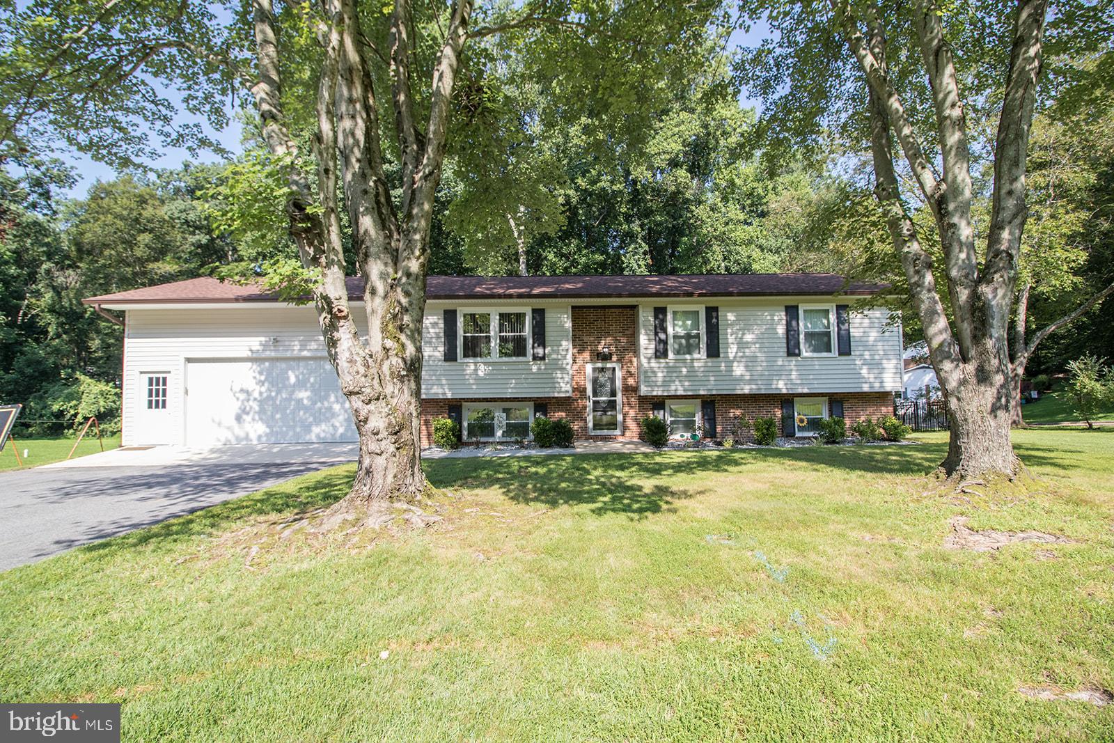 Beautiful and move-in ready, this 4-bedroom, 3-bath home sits on 1.08 acres near the end of a quiet street, backing to a peaceful wooded backdrop. Completely remodeled in 2015, the home features a spacious open-concept layout with a large family room flowing into the kitchen—ideal for entertaining. The main level includes three bedrooms and two full baths, including a private primary suite with ensuite bath. The lower level offers a fourth bedroom, full bath, and a generous rec room, perfect for guests, hobbies, or additional living space. Enjoy lvp flooring, fresh paint, and a rear deck for outdoor enjoyment. An oversized two-car garage provides excellent storage and workspace. A perfect blend of comfort, style, and privacy.