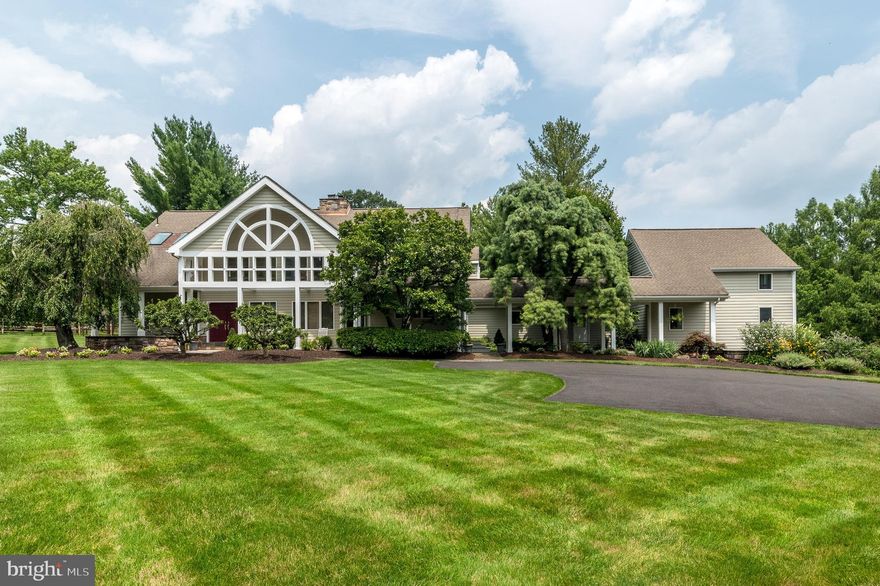 Captivating custom 4 Bedroom, 2 Full/ 2 Half Bath home with a unique blend of contemporary and colonial architecture, situated on a gorgeous, almost 2-acre lot in Blue Bell, bordering Gwynedd Valley, surrounded by horse farms and picturesque views. A stunning, hand-crafted, arched “screen wall” creates the covered porch spanning the front of the all cedar exterior and connects to a covered breezeway adjacent to a lushly landscaped courtyard. The interior is over 5000 sq ft, with windows positioned thru-out to allow maximum natural sunlight to stream through. The 1st floor provides hardwood floors, vaulted ceilings and spacious rooms flowing seamlessly from one to the next. The 2-story entrance w/wood ceiling, ceramic tiled floor and coat closet, includes the 1st of 2 Powder Rooms, w/copper fixtures. The formal Living Room connects, with pocket French doors, to the Office/Library w/custom bookshelves & cabinets and a French door is the 1st of 3 doors providing access to the rear of the property. An exciting 2-story Family Room, w/vaulted wood ceiling & multiple seating areas, is the show-stopper of this house. It features a gas fireplace (converted from wood-burning) w/hand-cut solid stone surround & raised stone hearth, w/natural light streaming in from the large atrium window above a full wall of floor-to-ceiling windows w/door providing access to the Deck.  The stone wall that continues to the ceiling of the 2nd floor adds warmth & charm & can be seen from below. The easy flow continues to the incredibly spacious, updated Kitchen w/granite counters, ceramic tiled backsplash, huge center island w/cooktop, peninsula w/seating for at least 3, built-in desk, glass decorative cabinets, under-cabinet lighting, double wall ovens & Breakfast Area with another full wall of floor-length windows & French door to Deck. A 2nd French door from this room leads to the courtyard w/planting beds & mature landscaping where you might envision growing vegetables or spices for the gourmet meals you can create. The extremely large laundry room includes several pantry closets adjacent to the kitchen, plus a 2nd Powder Room, washer, dryer and utility sink. This room connects to the oversized Garage with finished room above with a new HVAC system (2023), perfect for a Gym, 2nd Office, Playroom or Recreation Rm. This could also be an ideal 5th Bedroom, guest or in-law Suite, with private access from the Garage, and the nearby Powder Room could accompany this use if converted to a Full Bath. Hardwood stairs in the front Hall, w/newer carpet runner, lead to the 2nd floor hall, with a balcony overlooking the Family Room. There is newer carpet thru-out the 2nd floor. The Main Bedroom w/vaulted ceiling features a fantastic professionally organized closet w/built-in dresser, & a recently updated Full Bath (2021) w/quartz counters, Century cabinetry, Jacuzzi whirlpool tub, stall shower with new frameless glass door and 2 new skylights (2019). Bedrooms 2 and 3 each offer vaulted ceilings and exciting, connected lofts w/custom shelving, accessed by custom ladders in each room. Each room also includes custom built-in drawers, desks & shelving. The 4th Bedroom offers a special view of the front screen wall. The Full Hall Bath features corian counters & soaking tub w/shower. Let your imagination run wild with the possibilities in the huge unfinished basement w/multiple rooms, 1 of which includes shelving, a utility sink & a small, wall-mounted TV. Other extras include a newer hot water heater (2018), outlet in garage for electric car, radon remediation system, 3-zoned HVAC, WIFI thermostats & a security system. Experience the exterior, park-like grounds from the tiered, maintenance free Deck with planting boxes, surrounded by mature trees. Located within top-rated Wissahickon School District & less than 1 mile from the Gwynedd Valley train station. With views of horse farms and close to nearby horse trails, walking trails & parks, you will Love Lantern Lane.