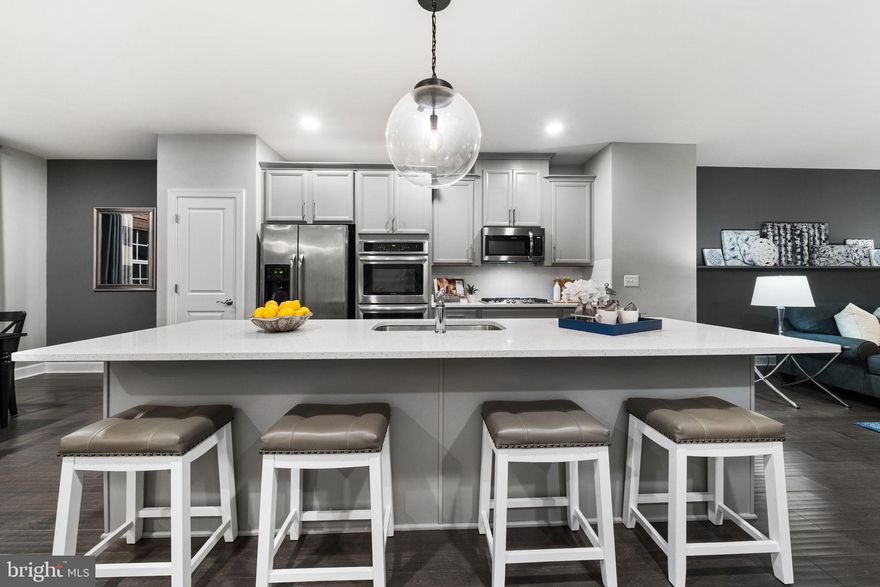 Welcome to the epitome of low-maintenance luxury in the highly sought-after Haymarket Crossing community. This meticulously maintained home shows like a model, offering a sophisticated blend of high-end finishes and long-lasting value.

The versatile floor plan begins with a rare entry-level den, thoughtfully utilized as a private fourth bedroom. This flexible space is ideal for a professional home office or an upscale guest suite, featuring direct patio access and a full en-suite bathroom.

The heart of the home is an entertainer’s dream, featuring an expansive open-concept main level adorned with luxury wide-plank flooring and designer lighting. The chef-inspired gourmet kitchen serves as the ultimate centerpiece, boasting a massive quartz island, premium stainless steel appliances, and sleek cabinetry that flows effortlessly into the sun-drenched living and dining areas.

Upstairs, the primary retreat offers a sanctuary of calm with tray ceilings, a spa-inspired en-suite bath, and custom-organized walk-in closets. The additional bedrooms provide generous space and abundant natural light. The luxury experience extends outdoors to a private composite deck and patio perfect for morning coffee. One car garage offer EV charging capability along with storage shelving.

 Living in Haymarket Crossing means enjoying a true "walkable" lifestyle. You are just steps away from nature trails, local coffee shops, boutiques, the Haymarket Village Center, UVA Health Haymarket Medical Center, and Sprouts Farmers Market. This home offers ultimate convenience and peace of mind, 1 car garage , the monthly fee covers water, sewer, and comprehensive exterior maintenance (including the roof, siding, and landscaping). HOA includes water, trash sewer,  visitor parking tots, playground and a gazebo.

 Ideally located for commuting and recreation, you are minutes from I-66 and Route 15. Residents enjoy easy access to Virginia Gateway in nearby Gainesville, featuring Wegmans, Regal Cinemas, and an array of upscale dining. The area is a hub for activity, home to championship golf courses, the Haymarket IcePlex, and the #1 ranked high school in Prince William County by U.S. News & World Report.