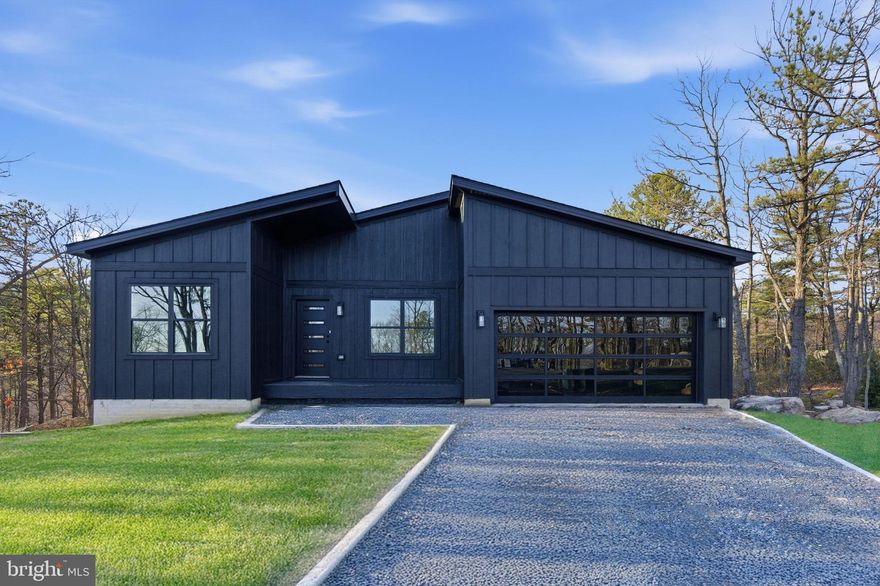 MOVE- IN READY!! This stunning new construction Mid-Century Modern home is nearly complete and located on a spacious 0.92 - acre lot in the desirable Woods Resort, offering beautiful mountain views . 
The Berkeley floorplan provides over 1,800 finished square feet on the main level, plus an additional 1,800 sq. ft. walkout basement with 9’ ceilings—perfect for future expansion or storage. The exterior showcases black siding for a bold, modern look. Inside features include luxury vinyl plank (LVP) flooring throughout, all-black interior doors with coordinating hardware, and a cozy living room fireplace framed by a black accent wall with wainscoting. The kitchen is equipped with white cabinets,  stainless steel appliance package, and a large center island ideal for entertaining. The spacious primary suite includes a bold black wainscoted accent wall and an en-suite bathroom featuring a barn door and  custom tile shower & modern finishes. Step outside to a 26’ x 10’ composite Trex deck with sleek cable railing, perfect for enjoying the peaceful natural setting. The home is eligible for Class A Woods Resort Membership, which offers amenities to indoor and outdoor pools, a spa, sauna, fitness center, golf courses, tennis courts, and more. Don’t miss the opportunity to own this stylish and thoughtfully designed home—