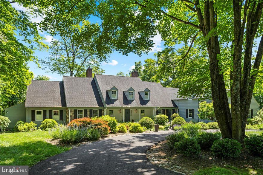 A peaceful hilltop treasure is what you will discover as you make your way to 1057 Crossing Farm Lane located just a short distance from the Delaware River and historic Washington Crossing Park. Tucked away on 8 lush acres of rural tranquility, this charming 5 bed, 4.5 bath country property offers superb character and appeal surrounded by natural beauty, wildlife and the sounds of nature. Enter from a striking bluestone front walkway and porch complimented by stone walls into a spacious, yet warm home with generously sized rooms and entertainment spaces. Enjoy picturesque views of the wooded landscape as you stand in the entryway and gaze through the bright formal living room’s oversized sliding doors. Eye-catching and impressive elements can be found around every corner throughout this beautiful cape such as the dual-sided wet bar shared by the family room and living room, the dining room’s full wall of custom built-in China closets and a hidden panel in the private Study. As you make your way to the expansive eat-in kitchen boasting a center island with cooktop and an abundance of cabinetry and work/prep space, access to a large deck which spreads across the entire length of the home making it the perfect setup for hosting gatherings. Conveniently located on the left wing of this level is the lovely, corner primary suite which boasts access to the deck, plenty of natural light, an enormous walk-in closet, large ensuite bath with dual vanities and connecting to a neighboring space which is currently being utilized as a study featuring a wall of built-in bookshelves. Completing this level is another spacious bedroom with full bath, a laundry/mud room with connecting half bath and garage access. On the upper level find 2 additional bedrooms, which share a full hall bath outfitted with two private vanity areas, bookend attic spaces that can easily be converted into additional living areas and a surprise bonus area over the garage with a private exterior entrance perfect as an in-law suite or for an au-pair or out-of-town guests complete with living area, kitchenette, bedroom and full bath. The expansive walk-out lower level is unfinished and offers wonderful storage. Additional home amenities include 2 wood-burning fireplaces, hardwood floors, side porch, newer well pump, and a whole house generator. Close to Newtown, Yardley and New Hope for shopping, dining, and historical sites, this home exudes warmth and allure amongst a beautiful backdrop and only a few minutes to the I-295 corridor.