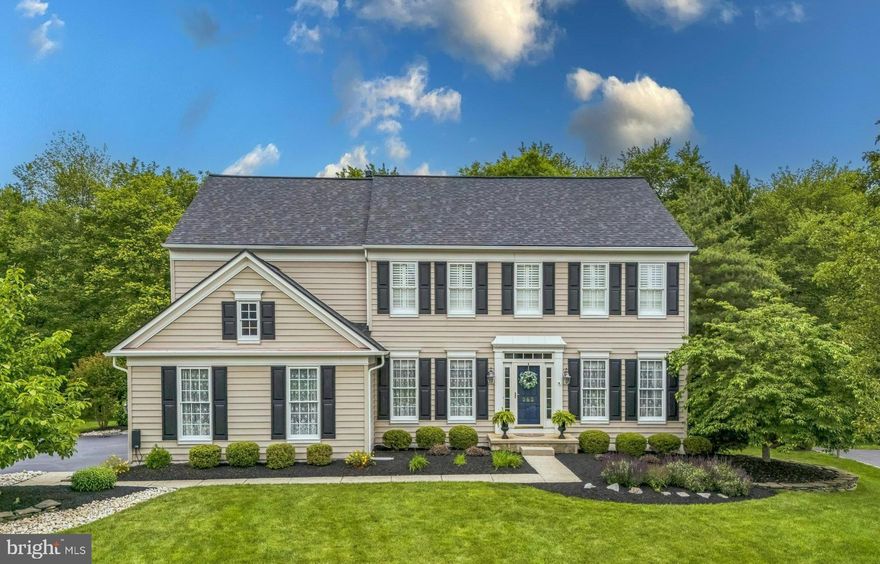 This impeccable colonial offers exceptional curb appeal and is ideally positioned on a premier lot in the highly sought-after Chestnut Creek community. Backing to serene woods and surrounded by lush, mature landscaping, the property provides a rare combination of privacy, tranquility, and picturesque views from every angle. A beautiful walkway welcomes you to a meticulously maintained exterior. Inside, the inviting foyer features hardwood flooring that continues throughout much of the main level. To the right, the living room showcases custom millwork and four windows that flood the space with natural light. To the left, the elegant formal dining room includes detailed dental crown molding and additional millwork, offering the perfect setting for holiday gatherings and entertaining. A private home office, enhanced with wainscoting and views of the wooded backyard, provides a quiet and inspiring space for remote work. The spacious family room serves as the heart of the home, featuring a cozy fireplace, soaring ceilings, and floor-to-ceiling windows that bring the outdoors in. This open-concept space flows seamlessly into the kitchen and morning room, creating an ideal layout for both everyday living and entertaining. The updated kitchen boasts white cabinetry, granite countertops, and a large center island with seating. Additional highlights include a bar and coffee station with a built-in wine rack, stainless steel appliances including a five-burner gas cooktop and double oven, an oversized sink, and a breakfast bar with additional counter seating. A walk-in pantry offers exceptional storage. The adjacent morning room is filled with natural light from a triple window overlooking the backyard, and includes recessed lighting, a sliding glass door to the deck with a retractable awning, and an additional door that opens to a stunning flagstone patio with a built-in firepit—perfect for al fresco dining, morning coffee, or evening relaxation surrounded by nature. A well-appointed laundry and mudroom with access to the garage adds everyday convenience, and a stylish powder room completes the main level. Upstairs, you’ll find four generously sized bedrooms with three full bathrooms.  One bedroom with a walk-in and one with double closet, while a third offers a walk-in closet and its own private en-suite bath. The luxurious primary suite is a true retreat, featuring a tray ceiling, a wall of windows with wooded views, and a spa-inspired bathroom with tile flooring, double vanities with a makeup area, a soaking tub, and an oversized stall shower. The large walk-in closet is fully outfitted with a custom organizational system. The finished lower level is thoughtfully designed to accommodate a variety of lifestyles and activities. It features a stunning wet bar with pendant lighting, a bar refrigerator, and seating, perfect for entertaining. A spacious game and media area offers room for hosting guests, movie nights, or game tables. There's also a versatile flex space that can serve as an exercise room, playroom, or hobby area. An expansive unfinished section provides abundant storage and room for a workshop or future customization. Additional updates include a new roof (2022), a hot water heater (2021), 2-zone heating/air conditioning (2019) and a whole-house generator (2015) for added peace of mind. Located just minutes from the PA Turnpike, award-winning schools, township parks, shopping, dining, and the local library, this exceptional home blends luxury, comfort, and convenience in one of the area’s most desirable settings.