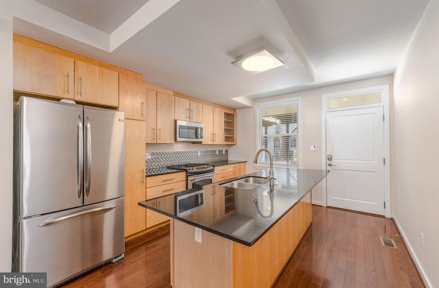 If you’re searching for a beautiful, modern townhome rental in Baltimore’s historic Patterson Park neighborhood, this Unicorn Listing may be your perfect fit! This two-bedroom, two-bathroom 1,454 sq ft home offers freshly-renovated features as well as a covered and gated parking pad. The home is equipped with an energy efficient tankless hot water heater.

The main floor offers an open-concept space with gleaming hardwood floors throughout that flow right into the kitchen. The kitchen is fitted with stainless steel appliances, a newly-redone backsplash, and black granite countertops, including an island with counter-height seating. 

The primary bedroom comes with built-in closets and opens out to a balcony, helping to bring in plenty of natural light. The updated main bathroom on the second floor, complete with fresh tiles, mirrors, faucets, and shower door, and has twin  sinks between the two bedrooms. The secondary bedroom also gets plenty of natural light from its large windows. 
The finished basement has a decorative concrete floor and is a flexible space, ideal for an office or study or an additional room for entertaining. The laundry area is also located in a large closet that can be closed when not in use, near the second full bathroom.

This home’s Patterson Park location puts you within blocks of the iconic Patterson Park as well as great local dining and shopping options. You’re about two miles from both 895 and Johns Hopkins Bayview Medical Center, and within blocks of US-40/Pulaski Highway. Two CityLink bus lines are also a block north.