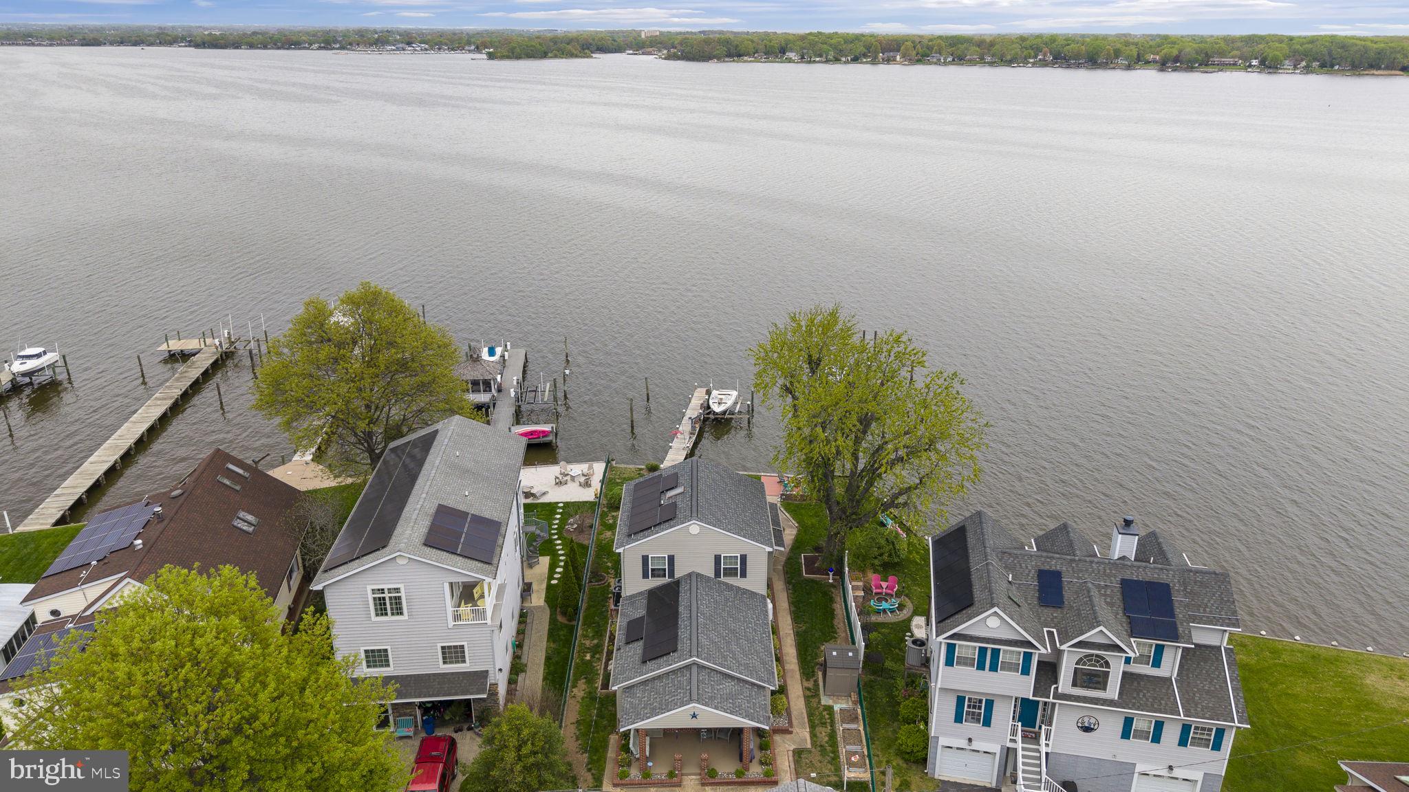 Discover serene waterfront living with this beautifully updated home nestled along 57 feet of scenic Back River shoreline. This 4 bedroom (or optional office) 2 full, 1 half bath property offers a perfect and unique blend of character, modern comforts and coastal charm, ideal for those who love entertaining or relaxing by the water.
Step inside to a fully renovated kitchen featuring a sleek glass cooktop, built-in oven and microwave, and new appliances (2020) including refrigerator, stove, and dishwasher. Crown molding and new LVP flooring flows throughout the home, complemented by fresh paint and recessed lighting throughout. Spacious family room with automated interior shades and stone accent wall.
The light and bright primary suite is a true retreat, complete full glass sliders for an unobstructed water view from your bedside. New upstairs full bath with an extra-large dual-head shower accented by a stylish barn door.
This home is built for convenience and sustainability with owned solar panels, dual-zone HVAC, a new hot water heater (2019), and a new roof (2015). Leaf filter gutter guards and hardscaping with river rock ensure low-maintenance beauty, while lush new landscaping, flower beds, and raised garden beds enhance the outdoor appeal. Fully fenced yard with an aluminum fence, two pedestrian gates, and a double locking gate for added security.
Enjoy waterfront features including a private pier, boat lift, and bulkhead, plus an outdoor terrace with fire pit and speakers—ideal for entertaining. Dedicated “boat room” with amazing water views. Additional perks include a detached 1 car garage with roll-up door and shed. Plenty of off street parking on this non thru street and tons of attic storage throughout the home.
Don’t miss this rare opportunity to own a private waterfront oasis with thoughtful updates and stunning river views.