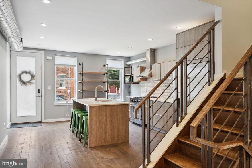 An idyllic, low-traffic block in sought-after Point Breeze is home to 1909 Latona St. This one-of-a-kind 3 bed, 2.5 bath residence has been recently renovated with modern design, thoughtful touches, a unique layout, and a roof deck, in addition to a private patio. Highlights include a tax abatement with 5 years remaining, a Nest system with a connected thermostat, smoke & CO detectors, a doorbell camera, and a new Kwikset virtual lock. Set on an extra-wide lot, the front of the home displays picturesque curb appeal in its pristine brick facade and lively planter boxes. Inside, you're welcomed by a gourmet kitchen at the front of the main level, one of the home's distinctive traits. Fully outfitted with custom wood cabinetry, stainless steel appliances including a high-end BlueStar range, an externally vented hood, quartz counters, a tile backsplash, industrial-style shelving flanked by bright windows, and an island with seating, this is surely the ultimate chef's kitchen! From here, beautiful hardwood floors and tall ceilings with recessed lights stretch past the center staircase, traced by a distressed iron railing, into the open, airy living room and dining area. The space is both wide and deep, with an industrial chandelier helping to define the dining area while a pair of glass doors fill the large living room with natural light. There's also a bespoke powder room for guests. Out back, the huge fenced patio is the ideal spot to create a peaceful garden oasis for relaxing on warm summer nights away from the city's hustle. Up on the second level, all 3 bedrooms have hardwood floors, ceiling fans, and tall bright windows. The two guest bedrooms share a modern full bathroom at the rear, while the primary suite features a custom closet and a sleek ensuite bathroom. Topping off the home is a pilot house, illuminated by a skylight, that leads to an expansive roof deck showcasing city views, perfect for hosting friends and family. For a future gym space and extra storage, the home is completed by a clean, semi-finished basement that holds the laundry. In addition to everything inside 1909 Latona St, this fantastic location earns a Walk Score of 87! Neighborhood favorites include OCF Coffee House, American Saradine Bar, Dock Street Brewery, and Porcos. There are also markets and playgrounds nearby, plus easy access to public transit, Broad St, I-76, and University City. Schedule your in-person or virtual tour today!