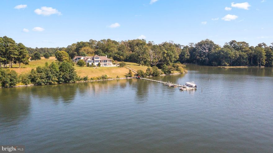 Stunning sunsets from this grand estate! Exceptional construction, coastal elegance & expansive water views all meet at this truly rare find on the Corrotoman River. Architecturally designed to take advantage of the Southwestern exposure, this home was built to be enjoyed. It has a wonderful floor plan offering an open flow of natural light & water views. The Kitchen was recently renovated w/ Quartz counters, Wolf gas stove, new hood, wall oven, Advantium microwave & Sub Zero refrigerator. The main level living room w/ stone fireplace opens to the waterside screened porch & deck. The primary bedroom en suite features vaulted ceilings, water views, private deck w/ hot tub, two large walk-in closets & spacious bathroom w/ tiled shower, free-standing bathtub & dual vanities. The lower level offers a large family room w/ wet bar, 3 bedrooms, 3 full bathrooms, an exercise room & temperature-controlled wine cellar. Walk-out to the waterside salt water pool area w/ patio. The pier offers 5ft.+MLW, boat lift, water & floating kayak docks. Efficient construction featured in the Superior Wall foundation, Hardi siding, Geo Thermal central air & Rennai water heater. Furniture & most furnishings convey!