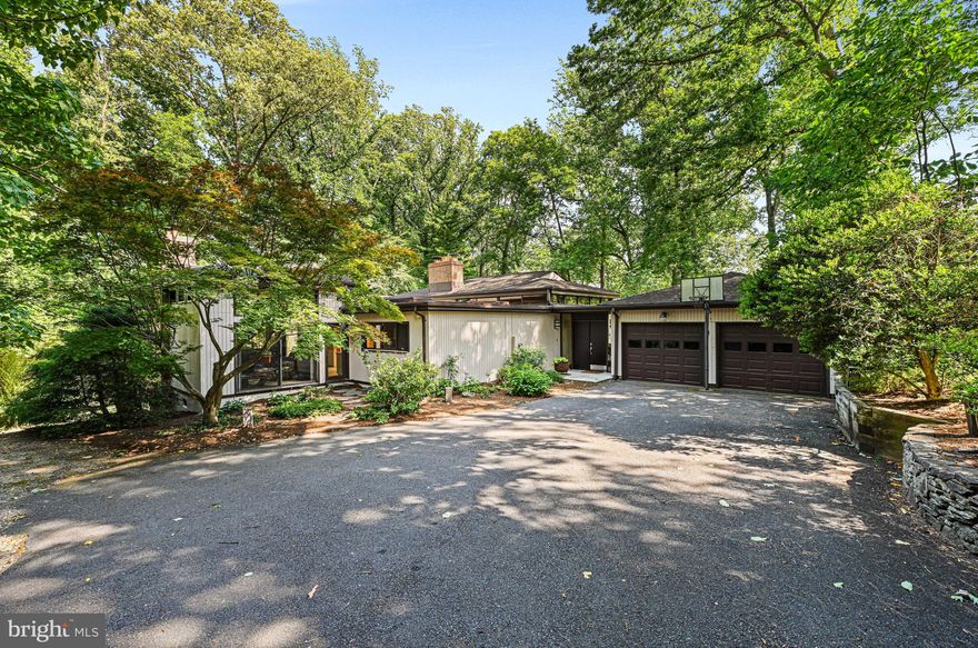 Modern architecture home with timeless design and appeal on private 5 acres with breathtaking views of Scotts Run.  Embassy size living room features four sets of floor-to-ceiling windows where natural light pours in and offers access to one of many decks.  The spacious dining room with wood floors connects to both living and the kitchen with an eat-in bar.  The family room opens to the kitchen and has built-in bookcases and cabinetry with a wood burning fireplace and provides access to both the front garden area as well as the side deck.  The primary bedroom is on the main level with a sitting area, private deck with stunning views and dual vanity bathroom with walk-in closet with built-ins.  The main level also has a power bathroom and library which can be flexible in space as another bedroom.  The lower level offers many options with what can be 3 additional bedrooms or living spaces and 2 full baths.  The understated appeal of the property offers so many possibilities!
