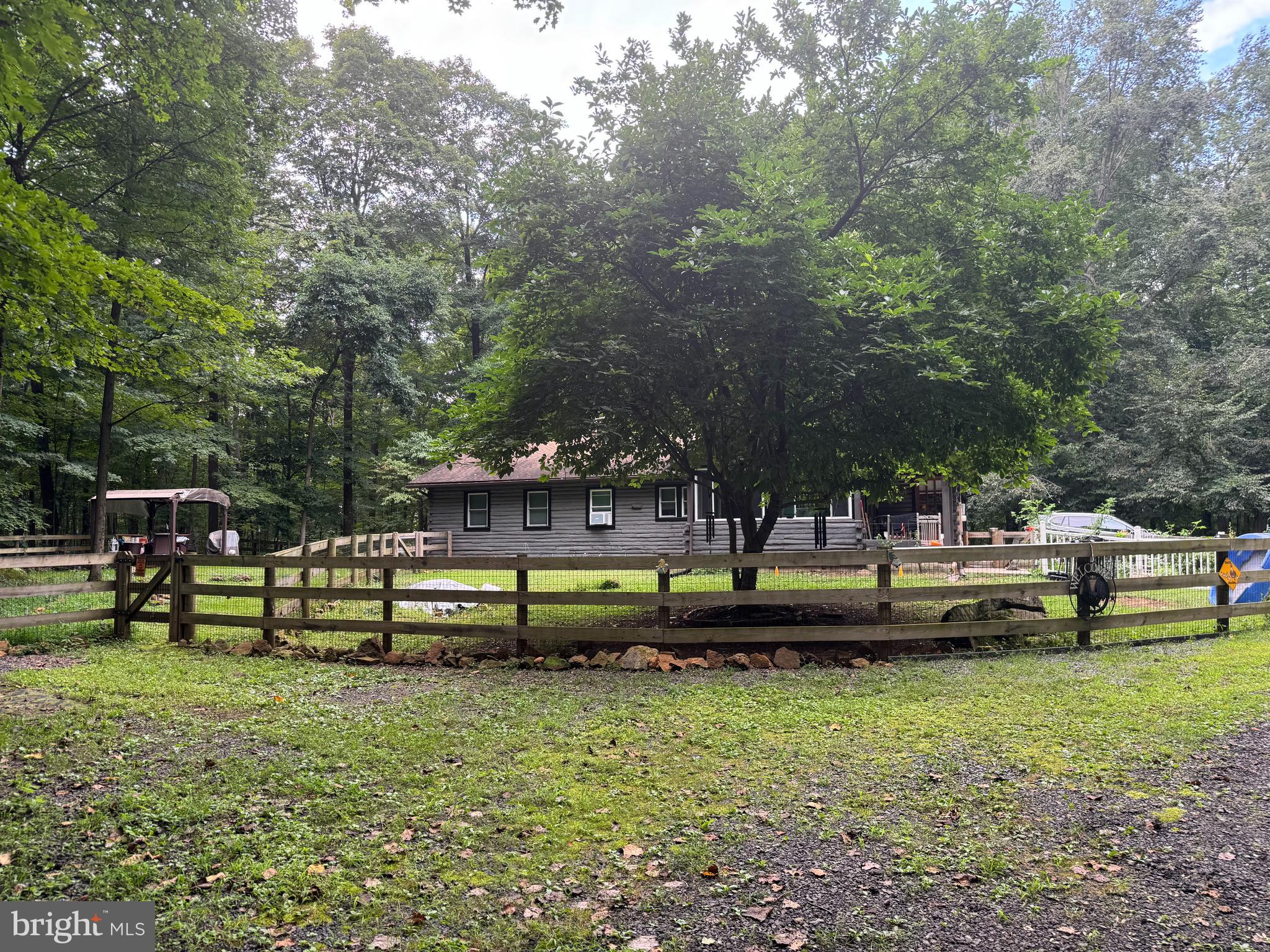Owner has been relocated so take this opportunity to own a log cabin in the woods. Â Driving down the lane to the log cabin brings natures best! Â You can spend evenings in the enclosed glass solarium staring at the sky, or convert this into a greenhouse, or spend your evening in the newly screened porch which has been updated for your viewing pleasure. Â When you arrive, you will notice the log cabin has been recently re-stained and treated. Newly installed windows and fencing surround the flatter grassy area where a pergola is perched for a forest view. Upon entering through the original wooden door, you will see an open floor plan containing a great room and kitchen. The antique German wood burning stove set against the stone fireplace is sure to catch your eye along with the newly installed vinyl flooring running throughout. Â A newly built bathroom, tiled but not completed, allows you to finish the bathroom of your dreams. A wall has been added to the study area to one day add a third bedroom. An attached two car garage can be entered through the vestibule, allowing access to both the storage over the garage and crawl space. Circling back through the kitchen and great room you enter the hall covered with rustic rock where you find two bedrooms and a full bathroom ready for use. To the right you will find the master bedroom waiting for your finishing flair, vinyl flooring has been purchased but not yet installed. Â Across the hall you will find another bedroom where the laundry has been located for your convenience.
The property is perfect for anyone seeking peace, privacy, and potential - whether as a full- time residency or a weekend retreat or investment. The current owner will miss the solitude and beauty of the woodland hideaway. Now it's your turn to claim this piece of heaven.
Opportunities like this don't last. Schedule your showing today!
This is an as is sale, but homeowner is offering a one-year home warranty.
Daughter works from home M-F, showings must be after 4:30 during the week.