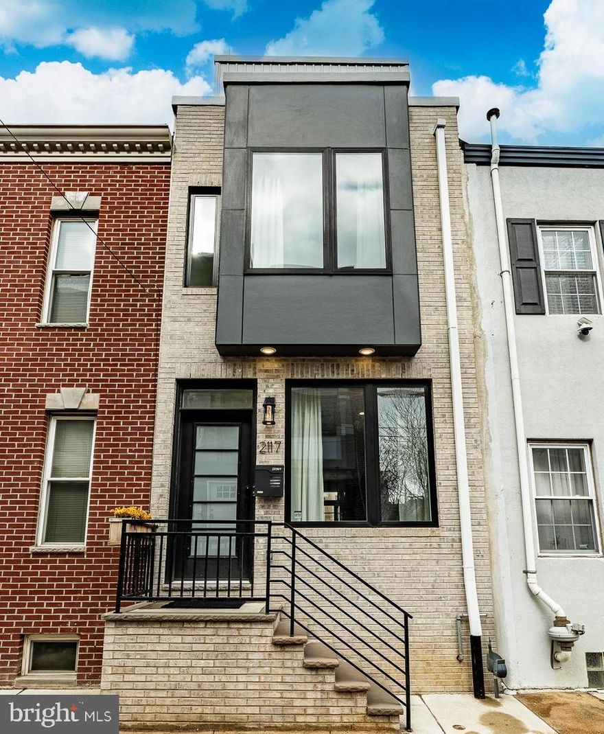 Offering peace of mind that comes with new construction, built in 2023 this stylish rowhome is now competitively priced for today’s market in desireable Point Breeze. The updated pricing creates a rare opportunity to secure modern design, energy efficiency, and low-maintenance living at exceptional value with 7 years remaining on the tax abatement. This stunning home offers an open floor concept with large windows with plenty of natural light.  There are stunning high-end finishes in the eat in kitchen complete with Quartz countertops, stainless steel appliances, breakfast bar with plenty of seating, pantry, 5 burner gas range and pot filler, exterior-vented hood and plenty of cabinet space. There is access from the kitchen to a private patio with privacy fence perfect for cookouts and entertaining with family and friends. The second floor offers 2 good size bedrooms, a full hall bath complete with tub/shower and smart mirror, and a convenient laundry room.  The third floor primary suite is complete with a large bedroom, walk-in custom fitted California Closet built-ins and a primary spa-like ensuite with heated tile floors, large glass enclosed walk-in shower with rain shower head and double vanity with smart mirrors. The next level comes complete with wet bar that leads to a private roof top deck with the amazing unobstructed views of Center City skyline…another amazing spot for entertaining or just relaxing. The fully finished basement offers additional living space ideal for a gym, office, or play area and a half bath. There is additional shelving for storage and an egress.  To complete the special additions to this home there is a built-in wired speaker system throughout the home and rooftop deck, a front-video door bell, Nest keyless entry and security capabilities with all of its equipment  ready for activation. This amazing home has all of the conveniences and more and is ready for you.