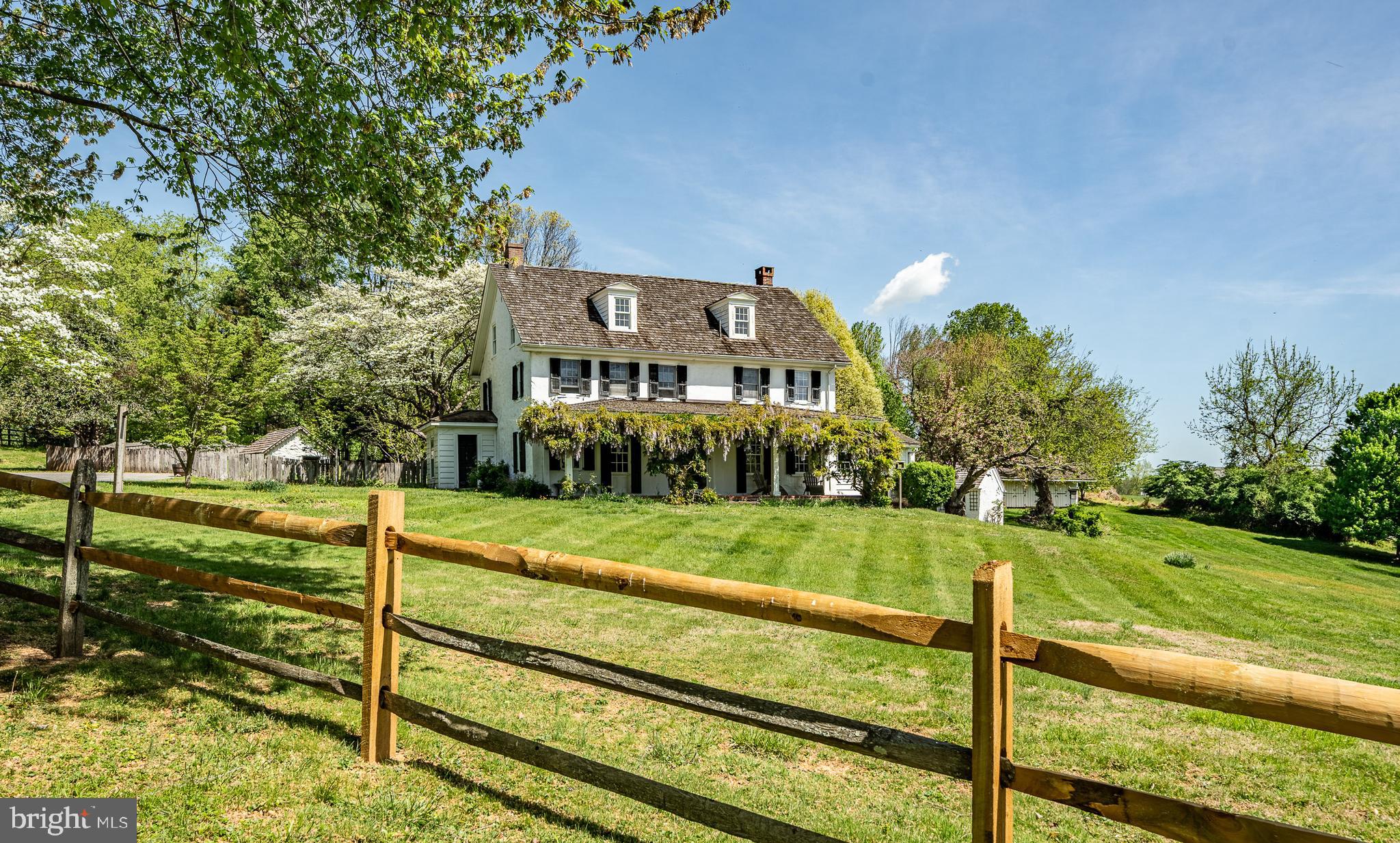 This impressive historic estate on Ivy Mills Rd. could be YOURS! Among the hustle of Delaware County is this unique, romantic property. The Walters House circa 1700 and its outbuildings are off Ivy Mills Rd. (formerly Walter Rd.) and sit on nearly 3.5 picturesque acres (2-parcel property of 2.3 acres and .95 acre backlot). Steeped in history, this stone farmhouse was built on 100 acres of land and purchased by Godwin Walter, a Quaker, who came to Philadelphia from England in 1685. The Walter family owned the property until the turn of the 19th century, then changed hands to another Quaker family who planted an orchard, and now to the Owners who made updates and additions throughout 2 decades - most recently renovated Bathrooms, updated cedar shingle roofs, pool house and stable, and more. Set back from the road, a split rail fence envelopes this 5BR 3½ bath 3,300 sq. ft. home that faces south and is magnificently perched on a sloping hill. 3-bay covered parking (16 x 32 workshop below), storage barn, 20’ x 45’ Pool House, in-ground Sylvan pool, stone milk house and stone building, ideal for a potting shed, all reside on the property and offer endless potential. A covered brick porch fronts this iconic 3-level farmhouse that is accented with myriads of outdoor spaces and breathtaking views of mature trees and verdant grounds. Step into the original wide plank oak and white pine floored Foyer and a traditional floor plan emerges. Architectural elements such as 6-inch baseboards, rustic exposed ceiling beams, foot-plus natural wood mantled windows, deep inset doorways and continued original hardwoods are throughout the home, lending charm and character. In the stately Living Room is the first of many wood-burning fireplaces combined with abundant natural light, creating inviting ambiance. A FP with brick hearth, larger and even more dramatic, is echoed in the Dining Room along with a twister staircase and walk-in nook that was converted to a full Wet Bar. Head back to a sunken, vaulted ceiling Kitchen where delightful bump-out floor-to-ceiling all-windowed Breakfast Area offers sunlight to highlight the built-in wood-burning FP nestled in a stone accent wall, chestnut cabinets, corner hutches and approximately 7’ x 4’ wide, wood-topped island with cooktop. Don’t miss the circular glass floor inset that reveals the original stone well. Adjacent to the Kitchen is a classic Library/Den with shelved-lined walls, a recently renovated half Bath with pocket door and Mud Room tucked off the back. Two flights of stairs both lead up to the Primary Suite, which offers ageless appeal with rich original poplar floors, charming exposed beams and stone wall, retreat area and en-suite renovated Bath. The 2nd and 3rd levels of home collectively feature 4 secondary Bedrooms and 2 full Baths, small kitchenette, and flex space, exercise room, or walk-in closet/dressing room. The grounds are spectacular where lush lawns blend into robust towering trees, and sunlit spaces give way to shaded havens. Brick walkway winds up to the in-ground pool with ivy-adorned trellis and surrounding half stone walls and private brick terrace. Formerly dubbed the pool house, this now flex space could be studio, office, or guest cottage thanks to its generous square footage, host of amenities and beautiful views. The main space of the pool house has a brick FP, exposed wood beams and ample room for conversation areas. Opens to a full Kitchen and wraps to a Bedroom, full Bath, Laundry Room and exterior access. The Barn sits on the far edge of the property, overlooks the front lawn and is a space that can be redesigned to be a brilliant fusion of an art studio, pottery nook, craft corner and more! Just 6 miles to Philadelphia Airport, merely 1.5 miles to Rts. 1 and 202 and resides in the award-winning Garnet Valley school district. This estate is a timeless treasure with a bright future, tucked in an unequaled location!