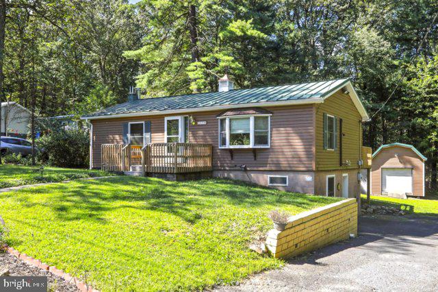 Welcome to lake life! 174/175 Totem Drive is a move in ready vacation retreat or full-time residence. Lake Wynonah is located less than an hour from Harrisburg, Reading, Allentown and Hershey. It is only 2.5 hours from New Jersey.
This completely remodeled 3BR/2BA raised rancher is located on a .67-acre lot surrounded by woods with two added decks, in a gated Gold Star community. The finished basement offers an office, 3rd bedroom/ mancave, laundry room/ pantry and 2nd full bathrooms. The office comes complete with a computer desk and bookcases stained to match the wood trimmed beams. The kitchen includes stainless steel appliances, vinyl plank flooring, and new wood cabinetry with beautiful countertops. The back deck off the dining room allows one to enjoy the trees and the abundance of wildlife in the woods. The kitchen, dining room, both bathrooms, downstairs bedroom/ mancave, and hallway were remodeled in 2023. The first floor living room and bedrooms were remodeled in 2019. The living room has 3 dimmable picture lights for a high-end look of sophistication. Roman shades will remain with the sale of the house. The first-floor bedrooms have ceiling fans and blinds to coordinate with the wood trim. The laundry room/pantry comes complete with washer, dryer, extra refrigerator/freezer, upright freezer, water softener, and pantry shelves to stock up on essentials. You'll enter the daylight basement into the mud area where you'll find a utility sink and extra shelving for storage.
There are 3 options for heating this house. Oil hot water baseboards / radiators, mini split HVAC heat pump system and an 8” flue hookup ready for a wood/ pellet/ coal stove. In the summer this place is cooled by the mini split system and ceiling fans. This is an extremely energy efficient abode!! The property has a shade garden along its Southern border. The garden has been meticulously cultivated for more than 20 years! The standing steel seem roof on the house was installed in 2014 and includes seamless gutter with gutter guard to make fall cleanup a breeze! This residence has premium Pella windows and doors, Baldwin Brass exterior lights, an 18' bronze flagpole and various gardens. If all this isn't enough, there's a heated workshop/storage shed which includes a lawnmower with the sale of the house. The steel roof on the workshop was installed in 2024 to coordinate with the house roof. This home has so much love and character, lots of bang for your buck!!
The home is located close to A and B docks, the lodge, outdoor pool, picnic groves and a playground for the kids. Lake Wynonah features two pristine lakes. Wynonah Lake is for boating, fishing, swimming, waterskiing, tubing and paddleboarding. Fawn Lake has no gas motors, allowing clean relaxed boating, canoeing, swimming, and fishing. There are multiple docks throughout the lake as well as a marina. The lodge has a restaurant, bar, tennis, pickleball and basketball courts. It's time for you to experience lake life in Lake Wynonah!!