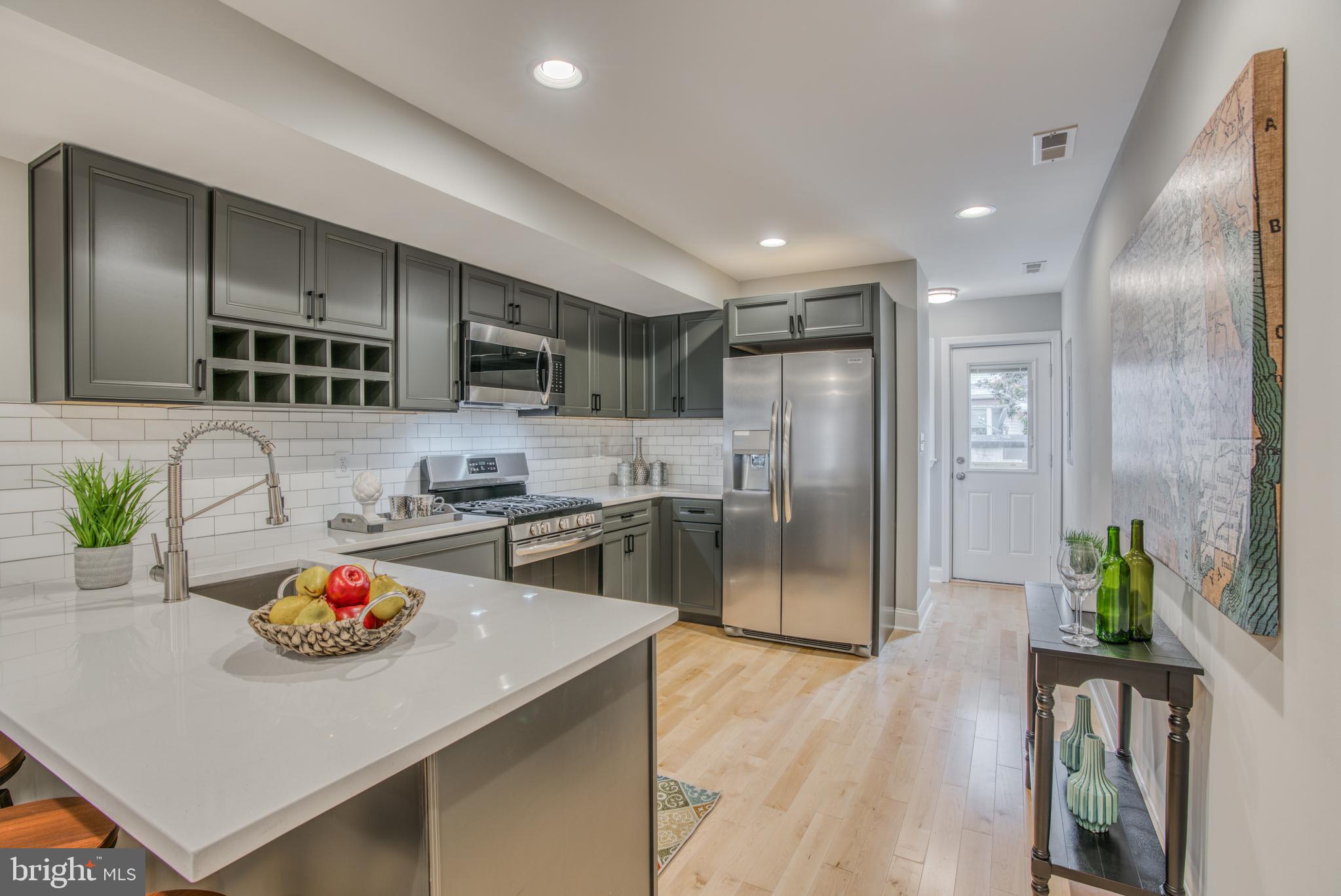 Exquisite renovation in Locust Point features 3 BRs, 3.5 BAs, gourmet kitchen w/ quarts counters, ss appliances, wine storage, soft-close cabinets & subway tiled backslash. Owner's suite w/ walk-in-closet, glass shower w/ mosaic tile accent & dual vanity. Finished lower level w/ possible 3rd BR/Office/Den w/ full bath and laundry. 3rd Fl party room, w/ quartz counters & wine fridge combined with the rear deck offers the perfect entertainment space! 1 car off-street parking. Latrobe Park, Under Armour & Merritt just blocks away!