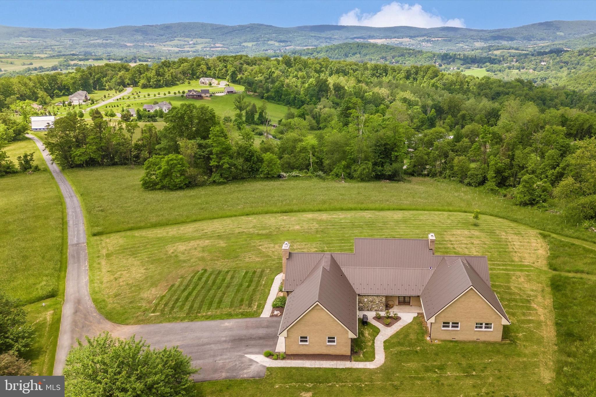 4534 Coxey Brown Road in Myersville, MD 21773 is a brick and stone single-level home on over 34 acres of serene landscapes, blending open fields with picturesque woods to offer unparalleled privacy and breathtaking views. Less than 20 minutes from Downtown Frederick and located in the Myersville/Middletown school district, this home offers an ideal combination of rural tranquility and urban convenience.
Meticulously upgraded, this residence features a recently remodeled kitchen with Medallion cabinets, Cambria quartz countertops, a walk-in pantry, and high-quality appliances including a Thermador oven, Fisher Paykel cooktop and Miele dishwasher. The living areas have been thoughtfully reoriented to enhance the flow and functionality of the space. Further adding to the home's charm, sustainable mixed-width ash hardwood flooring, sourced from property trees, complements the cozy wood-burning stove and hearth built with field stone from the property. Additional enhancements include new Sunrise vinyl windows, a new durable metal roof and gutters, a modern HVAC system, freshly repaved driveway, and an insulated two-door garage. With 3 bedrooms and 2.5 baths, this home offers both comfort and elegance. Additionally, a large barn offers plenty of space for storage, livestock, or a workshop.