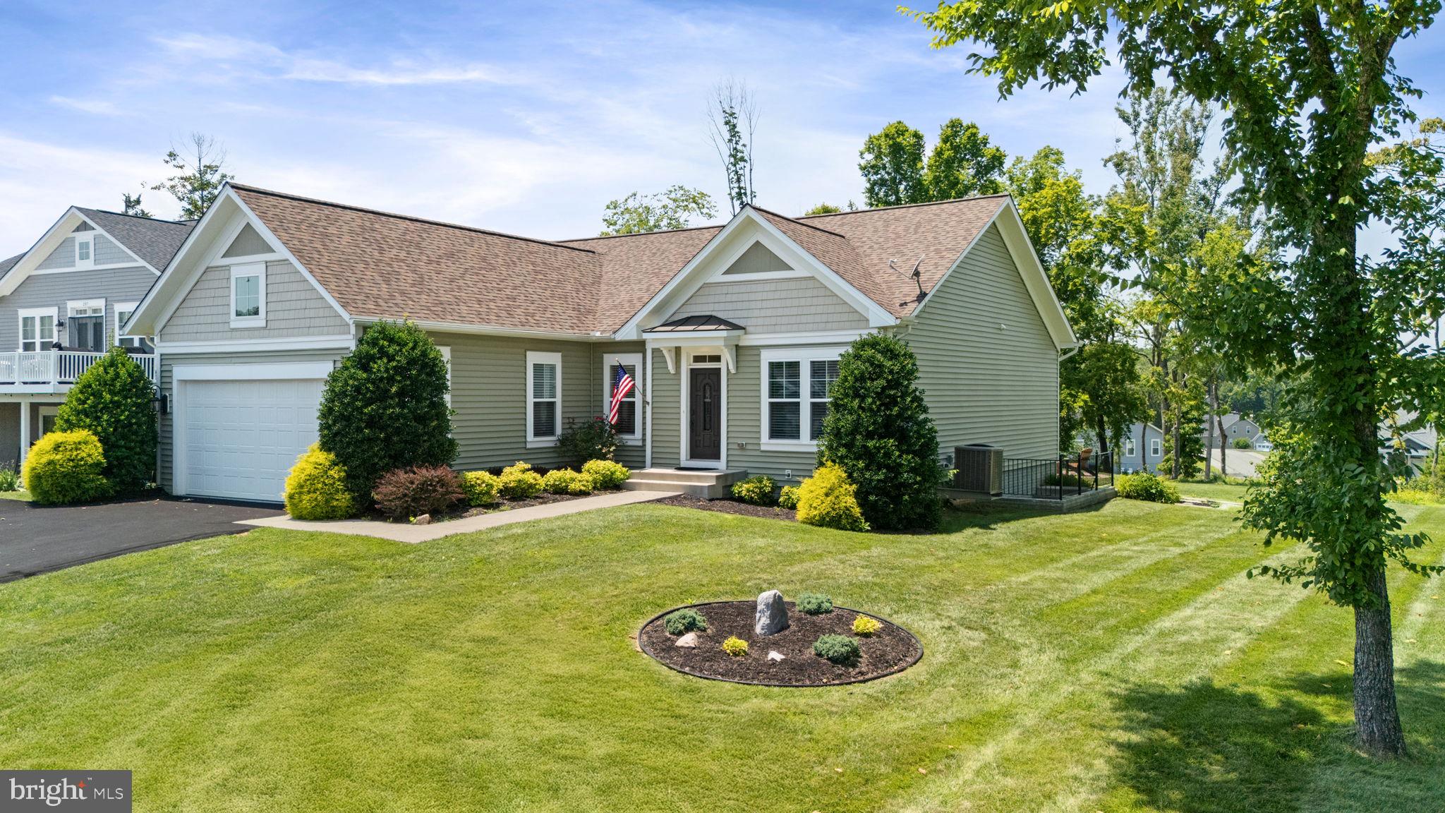 NEW PRICE!!! Water View Home on Public Side of Lake Anna w/ Covered Boat Slip and Community Amenities Galore!!! Welcome to 299 Sunset Loop tailored for true main-level living, open floor plan and expanded by a fully finished, walk-up basement. Beyond the Craftsman façade, resealed hardwood floors sweep through an open great room and island kitchen where 9-foot ceilings, stainless appliances, and double wall ovens form the heart of daily life. French doors off the great room open to a rear deck overlooking HOA-maintained lawn, mature woods, and the community walking trail; a set of wide stairs carries the party down to a stone patio with a built-in fire pit—perfect for s’mores under the stars. The main-level primary suite lies just down the hall, offering dual walk-in closets and a spa bath with soaking tub and separate glass shower, while a second bedroom—ideal for guests or a home office—and a dedicated laundry room complete the no-stairs convenience upstairs.
A broad staircase leads to the lower level, nearly doubling the living space. Here, a stone gas fireplace warms the family/rec room and is flanked by two generous bedrooms, each with its own full bath—ideal for visitors, multigenerational living, or hobby zones. The basement’s walk-up exit provides easy access to the backyard, making it simple to flow between indoor fun and outdoor relaxation. An attached two-car garage and paved driveway fits approximately six vehicles, and the HOA keeps the grass trimmed, so weekends stay free.
While the home takes center stage, its' setting perfectly compliments the lifestyle: a roughly quarter-mile stroll or a quick golf-cart ride brings you to your assigned covered boat slip, and the private community boat ramp, sandy beach, clubhouse, fitness center and pool. Close by lies the pickleball and basketball courts and a 45-hole disc-golf course with trails through the mature woods. If single-level ease, four ensuite bedrooms, wooded tranquility, and seamless indoor-outdoor living moments from the water are on your wish list, schedule your tour of 299 Sunset Loop today and discover how effortlessly lake-area living can feel. Minutes to grocery store, restaurants, breweries and marinas by land or lake!