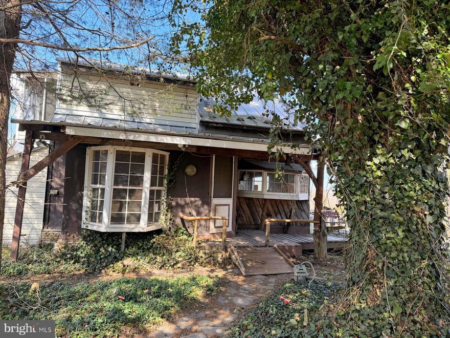 Enjoy 4.0 acres of waterfront property along the North River, located in Hampshire County, approximately 2.5 hours from Washington, DC. Set outside the flood plain, this property offers direct river access without the requirement for flood insurance, combining peace of mind with the beauty of true riverfront living.
The home is best described as a rustic cabin-style retreat, featuring a spacious open loft sleeping area and one full bath. Unique custom woodwork throughout reflects the artistry of a previous owner and adds warmth and character to the interior. It has electric heat and a wood stove, 200 amp service and an enclosed hot tub area offers year-round relaxation.
A three-bay detached garage has 100 amp service and multiple outbuildings provide ample space for vehicles, workshop needs, and storage of outdoor or recreational equipment.
With wooded acreage, river frontage, and a setting that feels private yet accessible, this property presents an excellent opportunity for a weekend getaway, recreational base, or full-time mountain retreat.  Power is easily accessible on lower river acreage. This property is being sold as-is and requires cash or conventional loan.

*** Please note:  this property is divided by the road so if you are standing with your back to the house/garage area ... the property continues across the road ... to the left of that is an access road where you will find a small gravel pile that leads down to the common area for community access ... beyond the black board fence to the right is this property.  It consists of approx. 1 +/- acres of flat ground with direct frontage on the North River.  Property is marked by orange ribbon.  If there are any questions, please contact the Agents listing the property.  See Plat in Doc Section.