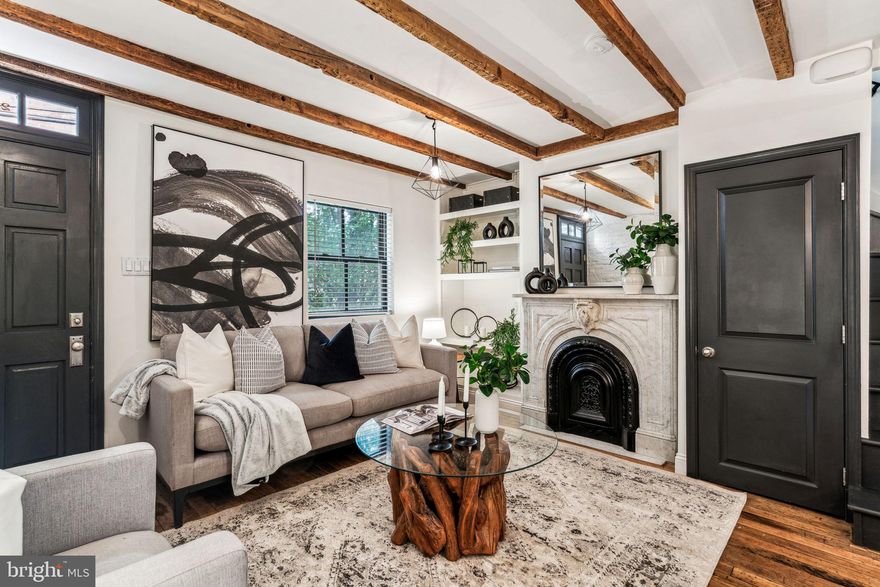 Welcome to 2125 Rodman St, a quintessential Philadelphia row-home on a quiet street that tastefully blends modern and historic style. Step into your warm living space with hardwood floors, a fireplace, exposed beams, and elegantly painted exposed brick. The updated kitchen features stainless steel appliances, a gas range, and quartz countertops, with plenty of cabinet storage and room to prep. Natural light pours in from the French door that leads out to the exterior with access to the shared alleyway.

The hardwood floors and exposed beams continue throughout, and the first bedroom upstairs has another fireplace. The white-tiled hall bath with wood accents continues the modern-historic vibe and is next to another French door that leads to the private rear deck with plenty of room for guests. The top floor is a large bedroom with two closets and vaulted ceilings, making it an inviting place to retreat from the fun of urban life and rejuvenate with restful sleep. The laundry is located in the clean and dry basement with additional room for storage.

Ideally located at the convergence of Rittenhouse Sq, Fitler Sq, and Graduate Hospital you are within walking distance of all the best the city has to offer. Neighborhood favorites and conveniences include Rival Bros Coffee, Pub & Kitchen, Friday Saturday Sunday, South Square Market, Sabrina’s Cafe, City Fitness, the Schuylkill River Trail, Fitler Square Park, and much more. Easy access to I-76, UPenn, CHOP, Center City, and in the Greenfield school catchment. Schedule your tour today!