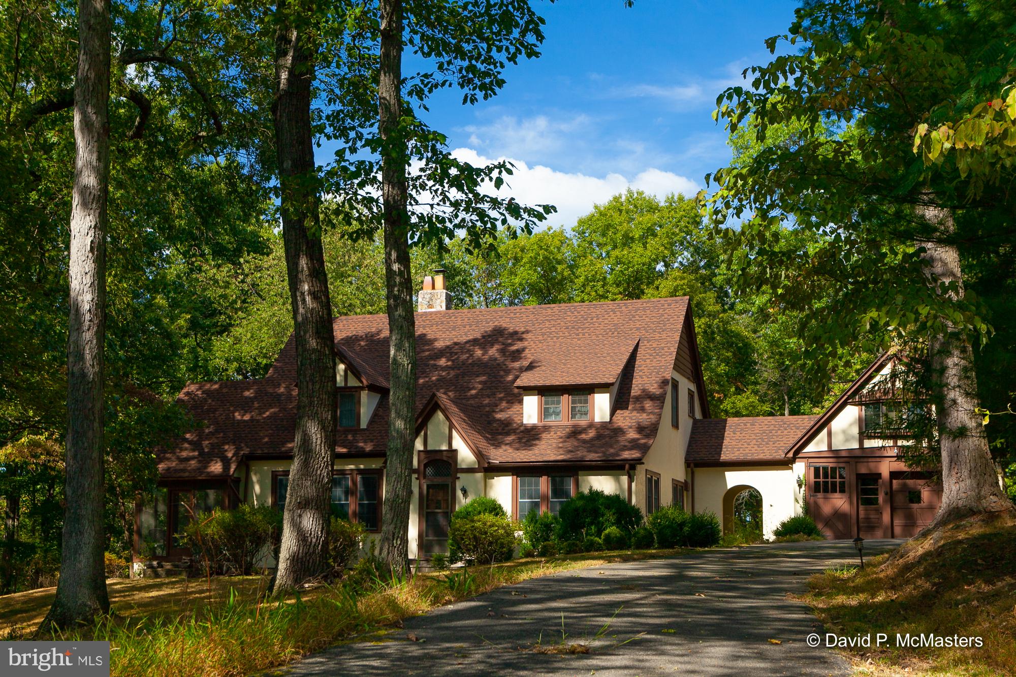 "FOLKE'STONE" Fairy Tale Setting A LOVELY SECLUDED TUDOR HOME down a long winding driveway off of Rte 9 just outside of Berkeley Springs. Formerly a B+B, it features lovely large rooms with wood accents everywhere, a 1st floor Master Suite and a handsome,separate, modern efficiency apartment over the 2 story garage. The best of many highlights is a BIG living room with a wall of built-in book shelves and a fireplace. The separate dining room has built in cabinetry along one wall. The kitchen is fully modernized and attractive. Please look at the photos to see all the wood features throughout the home and apartment. The screened back porch is comfy and quiet. In addition there is a detached 2 car garage. The upstairs bedrooms share a sitting room/family room. The 9.75 acre lot is simply GORGEOUS! There are tall trees everywhere and nice landscaping in the front yard. It is a charming, unique Country Retreat, and it could easily become a B+B once more. Private yet convenient. Near Cacapon State Park; hiking trails, horse back riding, beach, golf, lots of activities. Near C&O Canal for hiking, biking, horse back riding,kayaking cross country skiing. 30 Minutes to White Tail Ski Resort. Berkeley Springs is a great arts and history oriented small town, good restaurants, and the famous mineral baths (lots of spas); there are always lots of local activities.Travel Berkeley Springs provides a weekly listing of activities on their TBS website and the Berkeley Springs Chamber of Commerce site provides a good overview of the area and activities. Very appealing property. Current owners have made numerous changes and upgrades: all interior painting; added support in basement; conversion of iron pipes to PVC; New flooring both bathrooms and kitchen; refinished hardwoods (hallway, steps, and master); main level bath full restoration; new lighting kitchen, bathrooms, hallway, main level bedroom; in kitchen expanded cabinets, marble floors, all new appliances, butcher block counters, new faucets, new garbage disposal; new lighting in apartment; extensive exterior plantings. Full floor plan and interior measurements in attached documents.