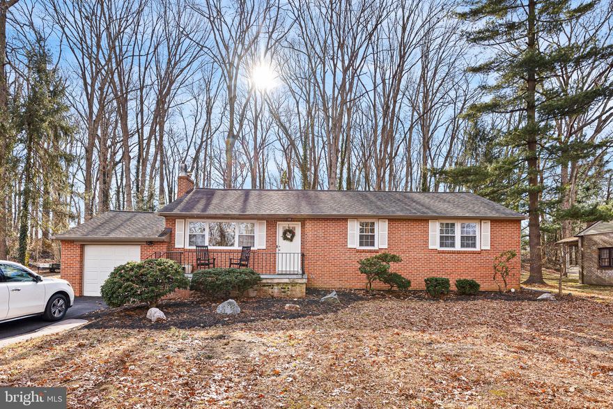 Tucked away on a private, wooded one-acre lot, this 3-bedroom, 2-full-bath rancher offers the perfect blend of peace, space, and everyday comfort—with no HOA and no restrictions. Located in an established community, this home feels like a quiet retreat while still being close to everything you need. Step inside to hardwood floors and a warm, inviting layout designed for real life. The open white cabinetry kitchen features quartz countertops, a beautiful backsplash, stainless steel appliances, and plenty of space to cook, gather, and connect. The family room centers around a beautiful wood-burning fireplace, creating the ideal spot for cozy evenings. Just beyond, an enormous sunroom with a gas stove adds year-round living space—perfect for large family gatherings, game nights, or relaxed weekends overlooking the trees. Outdoor living is just as inviting with a welcoming front porch and a rear deck that’s ideal for grilling or enjoying your morning coffee in nature. The one-car garage adds everyday convenience. Downstairs, the finished basement expands your living space with a second family room, a bonus room ideal for an office, gym, or guest space, a full bath and ample storage so everything has its place. Major updates provide peace of mind, including a new HVAC system in 2023, a roof approximately 6–10 years old, updated electrical, and public water and sewer. The hot water heater (2011) rounds out the home’s solid mechanicals. This move-in-ready home is a rare opportunity to enjoy privacy, space, and flexibility without sacrificing comfort. Schedule your private tour today and experience what it feels like to truly come home.