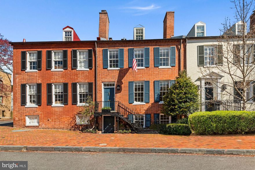 Located in the highly sought-after East Village of Georgetown, this timeless Federal-style home perfectly blends historic grace with modern luxury. A classic red brick facade is coupled with iron stairs, high ceilings, and a beautifully updated interior flooded with natural light that creates a soothing ambiance. Wide plank hardwood floors flow seamlessly throughout this spacious four-level home w/ over 3,100 sq. ft of living space, 5 fireplaces, 4 bedrooms, and 4.5 baths, and a stunning rear garden with ample space for entertaining.  Upon entering this stately Georgetown property, the main level conveniently offers an updated Chef's kitchen w/ a Viking Gas Range, Farmhouse sink, Sub-Zero Refrigerator, Bosch dishwasher all complimented by stunning cabinetry, built-ins, and a wood-burning brick fireplace. A separate dining room w/ a wood-burning fireplace opens to an expansive family room flooded in natural light from a skylight, oversized windows, and double French doors that open to a breathtaking slate patio w/ a garden perfect for entertaining or Al-fresco dining. The rear garden also offers a separate secured storage shed and private alley access to 28th St.  With an abundance of space and a light-filled interior, this home offers incredible livability. Two bedrooms including the owner’s suite w/ sitting room and a private terrace grace the second floor while a third bedroom is found on the top floor. Each bedroom offers a full ensuite bathroom for convenience. The lower level includes a spacious 4th bedroom w/ a wet bar, minifridge, ensuite bathroom, and built-ins w/ a work station offering the perfect solution for a Mother-in-law/Au-Pair suite.    Situated mere steps from Rose Park, this home is perfectly positioned to take advantage of its proximity to the shops and restaurants found in Georgetown, Dupont Circle, and Foggy Bottom. With a walk score of 94, this house is truly the perfect place to call home. (Additional parking can be rented 2 blocks away at The Four Seasons)