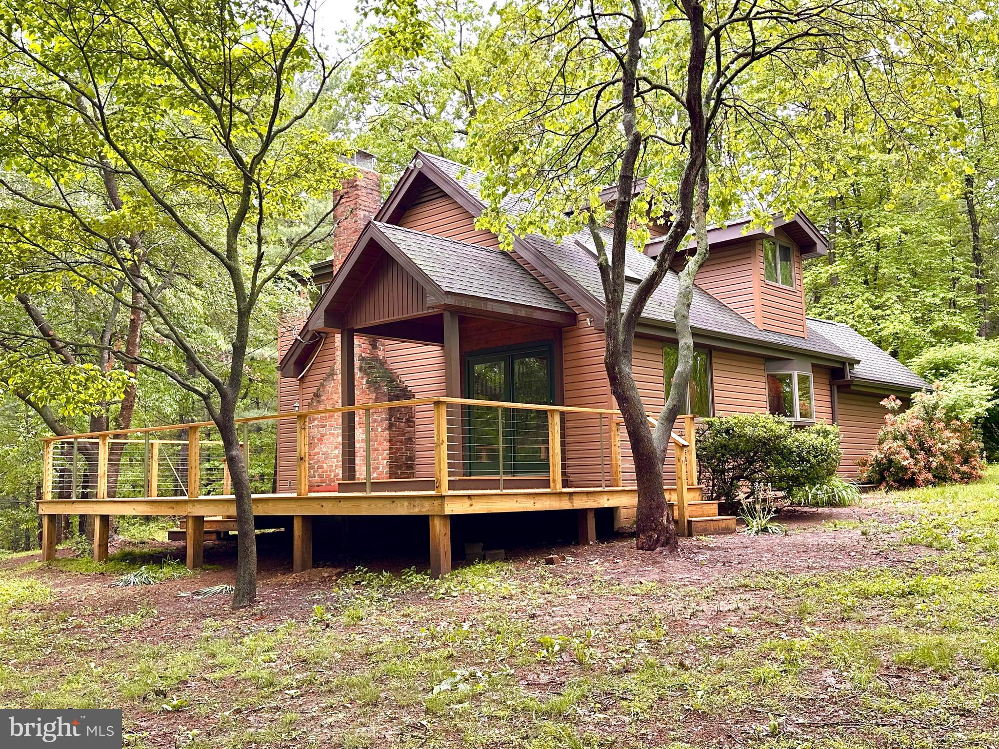 Welcome to your own private sanctuary nestled in the heat of nature. This home features 2 bedrooms, 2 full baths, a cozy living area with a fireplace and large windows that frame stunning views of the surrounding trees. The home that has been newly renovated with paint, flooring, updated bathrooms etc. Cathedral ceilings and great architectural detail in this home. The upper level is a en suite with large bedroom and full bathroom. A gorgeous, tiered, rear deck was just added to relax and unwind. Perfect for year-round living, a weekend getaway or even short-term rental opportunities. Detached garage/workshop. Property is two separate parcels of land.