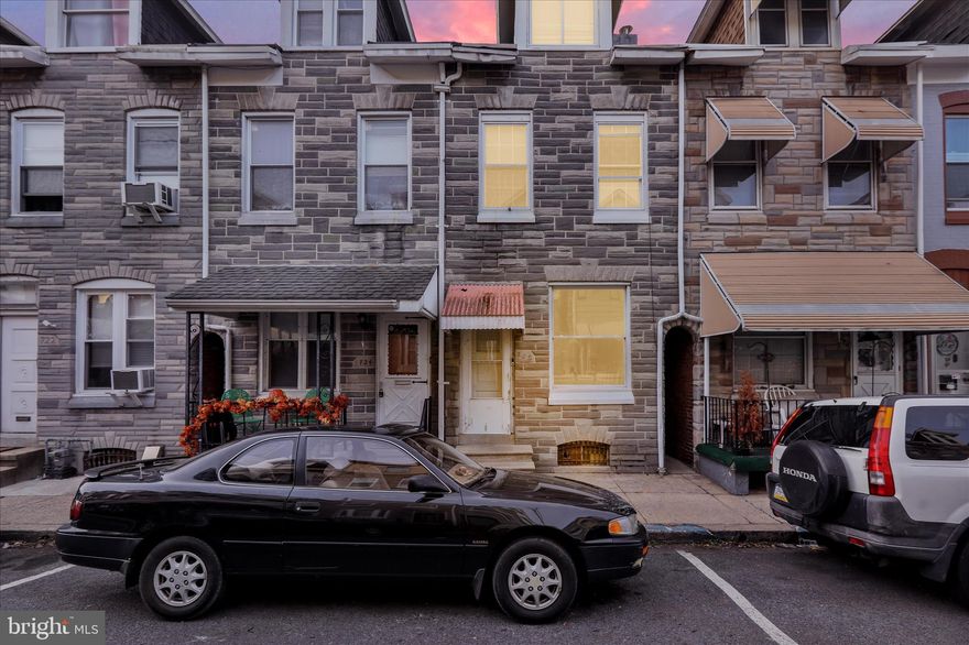 Welcome to this well-kept interior row home offering 3 bedrooms, 1 full bathroom and off-street parking. Built in 1900, this home blends classic Reading rowhome character with modern updates throughout. The main level features a bright living room, neutral paint, and updated flooring that flows seamlessly into the dining area. The staircase showcases traditional detailing while maintaining a clean, refreshed look. Toward the rear, the kitchen offers ample cabinetry, generous counter space, tile backsplash, and modern appliances, with natural light filling the space.  Upstairs, you’ll find three nicely sized bedrooms with updated flooring, neutral finishes, and good closet space. The full bathroom has been tastefully updated and features a modern vanity, tiled floors, and a glass-enclosed shower. Outside, the home offers a rear patio area with space for outdoor seating or storage, along with access to the alley behind the property. The stone façade adds to the historic charm of the block, which is lined with similar well-maintained homes. Conveniently located near local shops, schools, public transportation, and downtown Reading, this property is a great opportunity for owner-occupants or investors.
