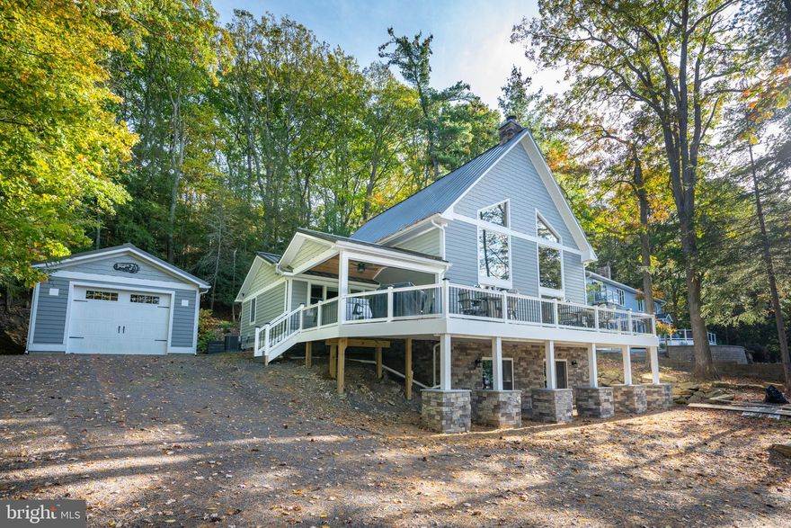 Tastefully Renovated Split Lake Front Cottage on Deep Creek Lake! Directly across the street from your private Type A Dock, This 4Bed 3Bath 1950's Lake Cottage is located on State Park Rd and has been renovated and re-built into a modern mountain masterpiece. Upgrades include a completely re-imagined great room with vaulted tongue and groove ceilings, stacked stone wood burning fireplace and plenty of glass to bring the abundant natural light and scenic lake views. Fully modern kitchen with hardwood cabinets, stainless appliances and granite tops. Brand new, finished walk-out basement with an added full bathroom. Stunning primary suite located on the upper level addition includes a large walk-in closet, fully tiled shower, two separate vanities and a luxurious soaking tub. Fully outfitted with brand new ductless AC system to keep you comfortable all year-round. Sprawling outdoor deck complete with a shiny new hot tub for relaxing on those perfect summer nights. Minutes from your favorite local establishments, state parks and Wisp Resort, this fully transformed Deep Creek Classic truly provides Lake Living at it's finest... Call today for details!