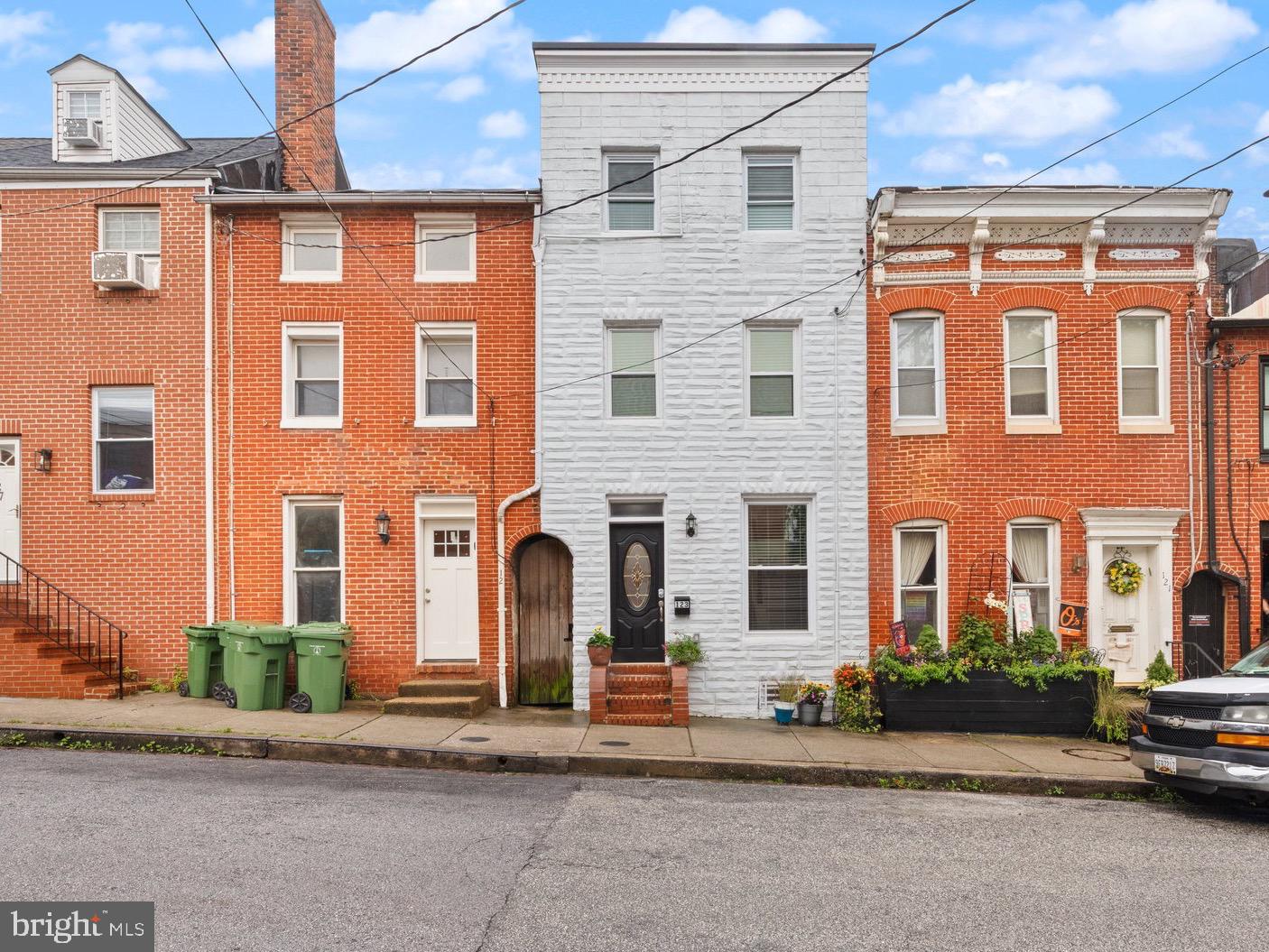 $10K Price Improvement! Welcome to 123 E Cross Street. This Renovated Federal Hill Gem is tucked just one block from Cross Street Market and surrounded by urban convenience, this beautifully renovated 4-level row-home offers over 1,800 square feet of stylish and functional living space. Low Property Taxes! With 4 bedrooms, 2 full baths, and 2 half baths, there’s room for everyone to spread out and enjoy. Completely gutted and renovated from top to bottom in 2023, this home features all new systems, plumbing, roofing, electrical fixtures, and finishes (all permits pulled through city)—truly move-in ready and designed for worry-free living. The main level features warm exposed brick, a convenient half bath, and a galley-style kitchen that leads to a fully fenced, oversized private patio—perfect for entertaining or relaxing under the tall trees that provide both shade and privacy. Bonus: The secure lot behind the home means no rear neighbors and added peace of mind for storing bikes or other personal items. Upstairs on the second level, you’ll find a primary suite with a walk-in closet, a charming ornate brick fireplace, and an updated ensuite bathroom with a double vanity and tile shower. A second bedroom on this level is perfect for a home office, nursery, or guest space.
The third level offers two additional generously sized bedrooms and another full bathroom. Each top-floor bedroom includes its own ductless mini-split HVAC unit, giving you personalized climate control and excellent energy efficiency. The fully finished basement provides a flexible space ideal for a hobby room, home office, or guest accommodations. This level also includes a utility/storage room with a slop sink and stacked washer/dryer—a thoughtful and practical setup for modern living.
Enjoy the perks of city living with a twist: green space across the street at the school is a great spot for pets or play, and non-permit parking on the school side ensures easy guest or long-term parking. Plus, a small school parking lot offers convenience for unloading groceries or large items. Technically the dumpster is for school use only ;) Use as a stand-alone investment property with an estimated $3200-$3400 month rental income or live in one bedroom as an owner occupant and rent the other bedrooms to cover your mortgage!
Don't miss this opportunity to own a turn-key home in the heart of Federal Hill—convenient to shopping, dining, parks, and more!