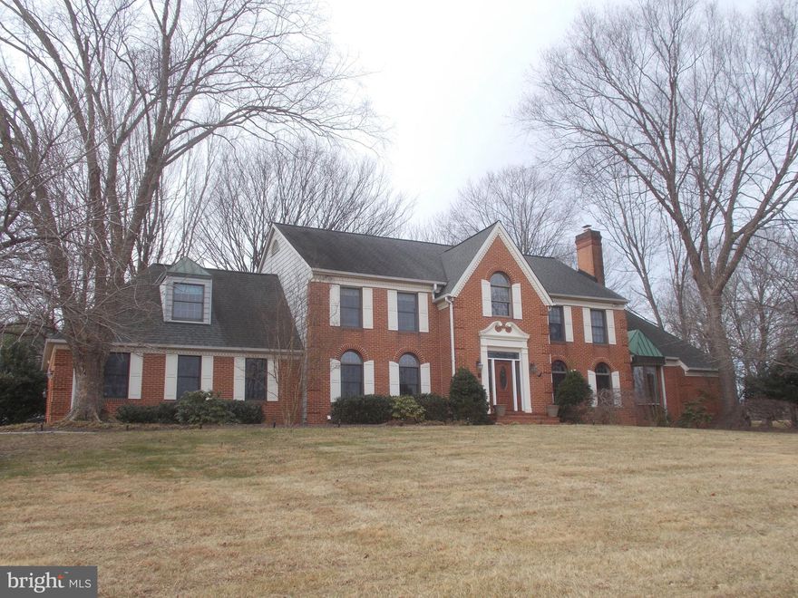 Gorgeous custom home on nearly 3 1/2 acres in the River Hill school district.  Grand foyer with vaulted ceiling; gleaming hardwood flooring; and curved hardwood staircase.  Separate Dining room with chair rail and crown molding;  glorious  hardwoods.  Living room boasts woodburning fireplace and crown molding.  Gourmet kitchen with vaulted ceiling; pendant and recessed lighting; skylights;  stainless steel appliances; granite countertops; soft close drawers and doors; 42" cherry cabinets; and luxurious hardwood flooring.  Brand new insulated slider opens to expansive paver patio with retaining walls.  Family room boasts an entire wall of custom designer palladian windows overlooking the backyard sanctuary; vaulted ceiling with fan; wet bar; woodburning fireplace; skylights; hardwoods.  New insulated doors to patio and backyard.  1/2 bath with pedestal sink convenient to family room.  Enormous primary bedroom on main level complete with sitting room; walk-in closets.  Primary bath has granite countertops; separate jetted soaking tub; huge tiled shower with multiple showerheads and pulsing jets; and skylights for tons of sunshine. Upper level boasts 4 generous bedrooms with ceiling fans and two full baths. Lower level offers expansive entertaining options to include a recreation room with tile flooring; wet bar; microwave and refrigerator.  Separate game room; separate office and den with built-in shelving.  Full bath with large shower.  Walk-in cedar closet.  Storage and utilities rooms.  Extensive hardscape brick patio and retaining walls out back with steps up to sport court.  Mud/laundry room as you enter from the garage. EV charger in garage! Upscale neighborhood; no HOA; and Blue Ribbon schools complete this amazing package.  Plenty of space for multi-generational living in comfort.  Welcome Home!