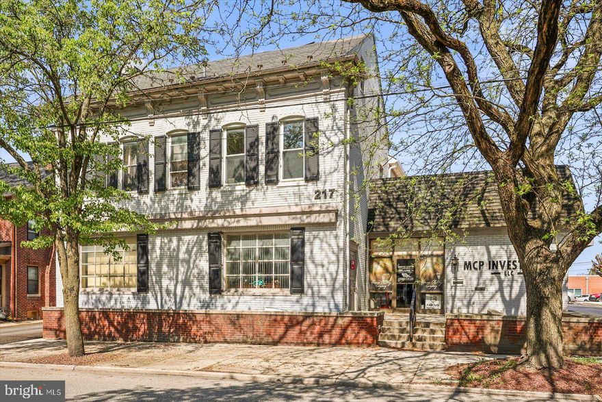 Endless Opportunity in a Prime Hanover Location!
Discover the potential of this versatile mixed-use commercial property, ideally situated just moments from the Hanover Square. With multiple income streams already in place and room to expand, this is a rare opportunity for investors or business owners looking to grow. The main building at 217 Frederick St. currently accommodates three business tenants who share a common area, along with access to two half bathrooms. The first floor features four private office spaces and is further enhanced by a vault and drive-up window, adding both character and functional versatility. The second floor offers incredible flexibility—currently set up for a potential 3-bedroom, 1-bath apartment complete with kitchen, living, and dining areas, or easily convertible into additional professional office.
To the rear, you’ll find a spacious 25-car asphalt parking lot, with several spaces already generating rental income.
The second structure, located at 7 College Ave., adds even more value. The upper level features an updated 2-bedroom, 1-bath apartment with modern LVP flooring, while the lower level includes a garage/storage space currently leased. With six income-producing tenants across office spaces, residential units, garage, and parking, this property offers immediate cash flow with upside potential. Positioned within mixed-use zoning and commercial districts, and just steps from the heart of Hanover, this property is truly a blank canvas ready for your vision. Expand, reconfigure, or simply collect income—opportunities like this don’t come around often!