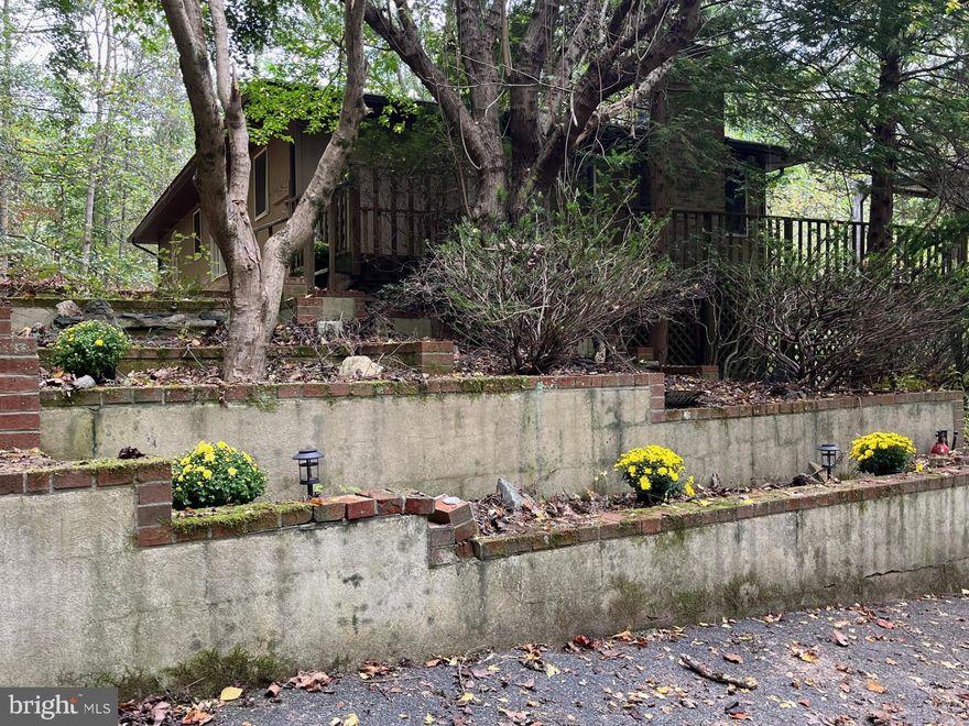Endless Potential Awaits! 🏡✨

Nestled on the edge of Rocks State Park in Northern Harford County, this rancher on 3.68 amazing, wooded acres offers incredible potential and a truly picturesque setting.

While this home is in need of a major renovation, the possibilities are endless! As you approach, a lower-level driveway provides extra space—perfect for parking a boat, camper, or additional vehicles. The upper parking area accommodates several cars with ease.

Beautiful terraced gardens lead you up to the home, featuring a charming fish pond on one side and a bird bath on the other. A spacious deck wraps around two sides of the house, complete with a pergola overlooking the serene wooded landscape—an ideal spot to relax and enjoy nature.

Inside, you’ll find a kitchen and dining combo with a granite breakfast bar and pantry. The dining area boasts hardwood floors and scenic views of the hillside, while the living room features hardwood floors and a large bay window that fills the space with natural light. Both bedrooms offer hardwood floors and double closets, and the hall bath includes a tub/shower combo and linen closet.

The lower level provides even more living space with a rec room featuring a woodstove/fireplace, a bedroom, and a full bath with shower. Both rooms open to the lower-level patio through sliding doors. The deck above is supported by sturdy steel beams and posts.

Imagine cozy evenings by a fire pit, roasting s’mores, soaking in a hot tub, or simply taking in the tranquil sounds of nature. Just minutes away, you’ll find Rocks State Park’s scenic trails, trout streams, and waterfalls, plus local favorites like Kilgore Falls, Slate Farm Brewery, and Fiore & Harford Vineyards.

Whether you’re looking for a weekend retreat or your dream home just 15 minutes from Bel Air, this property has the setting and potential to become something truly special.

Sold As-Is. Recent updates include a new main electrical line and electric panel. Electric runs to the well and furnace but they are currently off. Please schedule your showing online — a Hold Harmless Agreement must be signed prior to viewing.