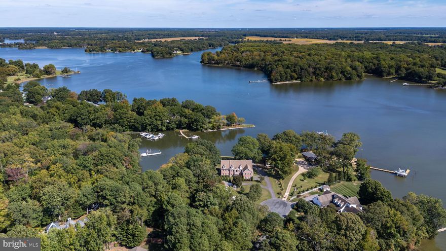 If you love the water, this extraordinary Wye River property is a dream setting. Situated on the point with more than 1,400 feet of waterfront, this property is fully equipped for waterfront living with two piers, a private beach, and a boat launch.
The custom 6,400-square-foot home offers exceptional space and comfort, featuring a brick front, four-car garage, double porches, and walkout access. Inside, the kitchen is beautifully appointed with granite countertops, solid wood cabinetry, a gas cooktop, stainless steel appliances, and both a full-size refrigerator and freezer. Brazilian cherry floors and tile throughout the main living areas add warmth and timeless character.
The main home includes four bedrooms, with a spacious first-floor primary suite for convenient main-level living. A bright sunroom, also perfect as a crab room, adds even more charm to the first floor. Upstairs, two expansive living areas showcase sweeping 180-degree water views. These flexible spaces are ideal for a game room, media room, lounge, or additional gathering areas.
A standout feature of the property is the full private apartment with its own entrance through one of the two garages. Complete, with a full kitchen, two bedrooms, a full bath, separate laundry room, living room, and dining area, it is ideal for extended family, guests, or possible rental income.
Outside, the property continues to impress with a waterfront fire pit, storage, water and electricity at the piers. There is also room for a pool on the right side of the property, subject to county confirmation.
Offered for the first time, this exceptional waterfront retreat is ready for its next owner.