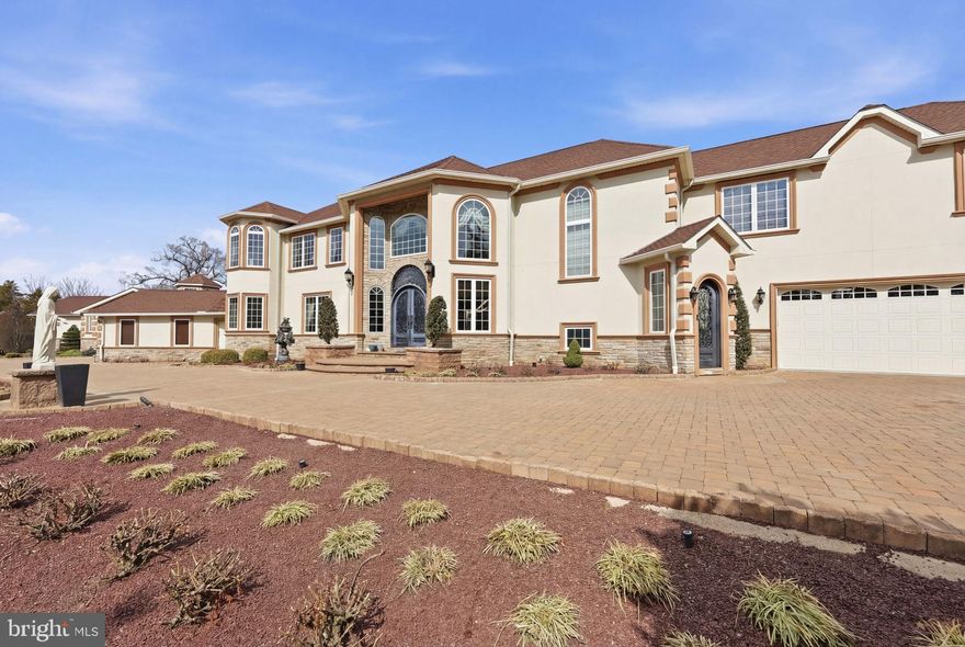 1066 Washington Crossing Road, Newtown, PA is one of the most extraordinary private estates ever offered in Bucks County. This fully gated and entirely fenced custom residence spans nearly 10,000 square feet of refined living space, offering approximately 8,000 square feet above grade plus an additional 2,000 square feet of finished lower-level living. Designed without compromise and built with no expense spared, the home delivers a rare combination of privacy, architectural significance, and lifestyle versatility within Upper Makefield Township.

The residence features six bedrooms plus a dedicated office, six full bathrooms and three half bathrooms, and an exceptionally rare open-concept floor plan that seamlessly connects grand-scale entertaining with everyday living. From the moment you enter, the home impresses with soaring ceilings, hand-crafted millwork, ornate plaster detailing, marble floors, and dramatic chandeliers—timeless details that reflect true custom craftsmanship throughout. The showpiece kitchen anchors the home and flows effortlessly into expansive dining and living spaces designed to host at the highest level.

A standout feature of the property is the expansive in-law suite, which functions as a home unto itself and offers two bedrooms, two and a half bathrooms, a full kitchen, and a private laundry room—ideal for multi-generational living, extended stays, or guest accommodations. In total, the home includes three separate laundry rooms for maximum convenience. Additional lifestyle amenities include a climate-controlled wine cellar, a half indoor basketball court, a beautifully designed outdoor pergola, custom garage space, and thoughtfully finished lower-level living areas that further enhance the estate’s functionality.

Built for comfort, security, and peace of mind, the home is equipped with a full-house generator supported by a 1,500-gallon underground propane tank, allowing the property to operate off-grid for extended periods if necessary. A state-of-the-art smart-home security system integrates cameras, gated entry controls, lighting automation, and advanced monitoring throughout the estate. Whole-home surround sound music systems extend through virtually every room, creating a fully immersive and connected living experience.

Additional highlights include five walk-in closets, a dedicated home office, and a layout that perfectly balances grandeur with warmth and livability. Located in the highly sought-after Council Rock School District and just minutes from the charm of Newtown, this is more than a residence—it is a legacy estate offering privacy, scale, and craftsmanship that simply cannot be replicated.