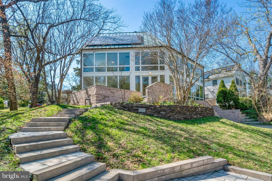 6559 24th St N is a rare luxury parkside paradise where sleek design meets natural beauty and urban convenience. With breathtaking, floor-to-ceiling windows framing unobstructed park views, this contemporary masterpiece blends sleek design with a serene connection to nature. Nestled on a quiet cul-de-sac just steps from Tuckahoe Park, Tuckahoe Elementary School, and the East Falls Church Metro, this 4-bedroom, 4.5-bathroom oasis spans nearly 4,000 square feet across four thoughtfully designed levels, offering both the convenience of Arlington and the charm of a small town. 

The heart of the home is the open-concept main level, where sunlight floods every corner, creating a bright, airy ambiance. A chef’s kitchen with quartz countertops, new custom cabinetry, and stainless steel appliances flows effortlessly into the dining and living spaces. Walls of glass capture the ever-changing beauty of the park, providing a sense of tranquillity rarely found in city living. 

The second level features the primary suite, offering a spacious bedroom with panoramic views of lush greenery, a generous walk-in closet, and a renovated spa-like en suite with a soaking tub, frameless glass shower, and dual vanities. The second level also includes two additional bedrooms, a hallway bathroom, and a versatile flex space, ideal for a home office or a cozy upstairs living room. A spiral staircase leads to the top level with an additional bedroom, cedar closet and full bathroom, making it the perfect private guest suite or an exciting playroom. A walkout lower level with a recreation room and full bath completes this exceptional layout. 

With fully paid for solar panels connected to a home battery, a copper roof, a 3-zone HVAC system, large 2 car attached garage and high-end finishes throughout, this home is a rare fusion of luxury, efficiency, and natural harmony. The prime location makes this home a commuter’s dream—just minutes from I-66 and the Metro for seamless access to the city. It’s the perfect blend of urban amenities and small-town charm, with both Westover Village and Falls Church City just moments away.Skip the 10+ year waitlist—Overlee Swimming Pool membership available for immediate transfer! Zoned for Tuckahoe Elementary, Williamsburg Middle School and Yorktown High School! Opportunities like this don’t come often—experience a one-of-a-kind retreat in the heart of Arlington.