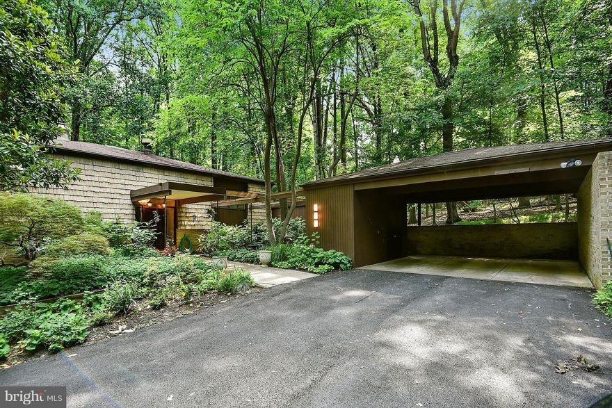 Beautiful two-story split foyer contemporary by Howard Rodman. 5 Bedrooms/2.5 Baths on 1.26 wooded acres with many new updates. Main level features walls of windows overlooking mature landscaping and full patio, 2 sided FP in Living Room & Fam Room, 8  Sunroom, Dining Room, Den and Kitchen with Breakfast & Laundry areas. Double carport with covered walkway. Lots of storage.