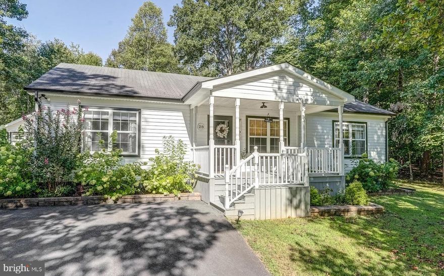 Straight from the pages of Southern Living Magazine, this newly renovated and enchanting country cottage will immediately elevate your lifestyle, and leave you smiling, ear-to-ear.   Located in the idyllic Lake Monticello community, this adorable home recently enjoyed a complete head-to-toe makeover, including: new white quartz countertops, LVP flooring, new custom wood kitchen cabinets, stainless kitchen appliances, luxurious tile backsplash, renovated bathrooms, new lighting, incredible farm sink, wood-burning fireplace and mantle, new plumbing, and even more improvements!  Outside renovations include beautiful new white siding, black window trim, a new HVAC, new plumbing/pipes, new screens, fencing, and more.  All of these improvements are listed in the documents section.  This cozy abode offers over 1,300 square feet, and is anchored around a large family room, featuring a lovely wood-burning fireplace and chunky statement rustic mantle above.  The spacious primary suite includes a walk-in closet, designer wallpaper, ceiling fan, and en suite bathroom, vanity, tile flooring, and beautiful glass shower door with elegant black trim.   Your guests will enjoy the spacious guest room and second full bathroom with shiplap and elegant countertops.  The kitchen is open, spacious, and features custom wood cabinetry, a large peninsula with bar seating, recessed lighting, and smoothly connects to an open dining area with large storage closet/pantry showcasing rustic barn doors.  This home also offers a separate laundry room off the kitchen with washer and dryer.  Unwind outside in the extremely private, fairytale-like courtyard, complete with shaded seating beneath a lovely gazebo, constructed on a hardscape patio, a relaxing rock waterfall, hammock, lots of natural shade, large back deck attached to the home, and plenty of private shaded yard space.  This property also offers are big detached two-car garage, as well as a convenient storage shed with storage shelving.  In addition, you'll also enjoy all of the incredible amenities Lake Monticello has to offer, including a private lake, boating, fishing, 18-hole golf course, tennis courts, swimming pool, sandy beaches, a walking track, and much more.