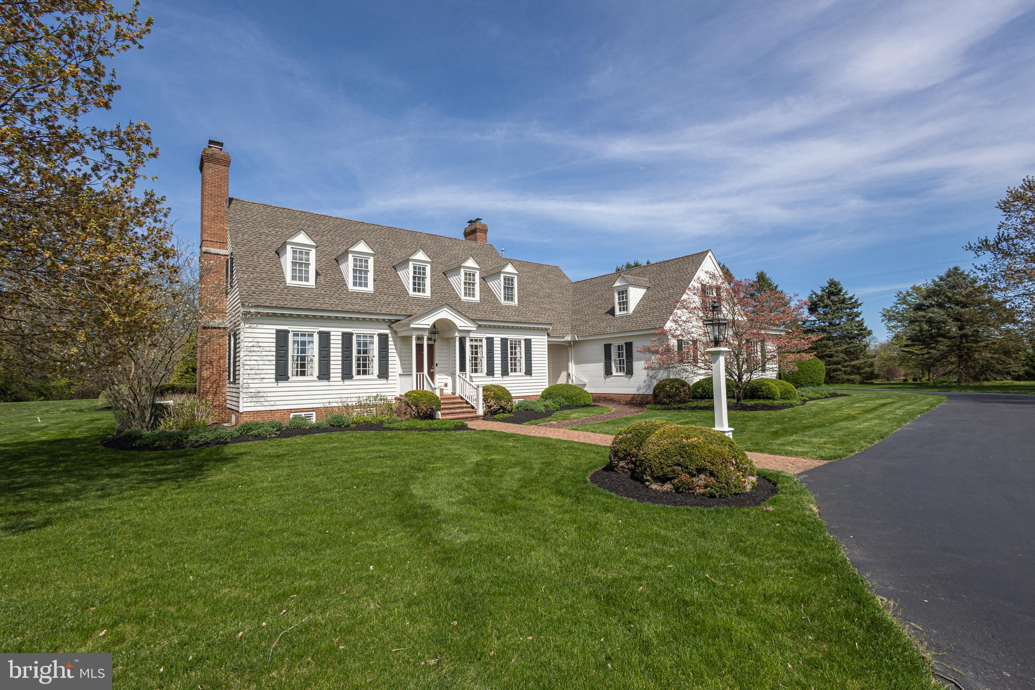 Escape to the tranquility of bucolic Bucks County in this exquisite Williamsburg inspired home. Custom built by Neil Trueblood, this enduring home is nestled on nearly two acres of picturesque land within the exclusive Ely Farm community. Boasting timeless charm and modern amenities, this stunning property offers the perfect blend of elegance and comfort. The beautifully manicured yard with farm views and a sweeping driveway enhances its stately curb appeal. Featuring 4 bedrooms, 2 Bonus Rooms and 4.5 bathrooms, there is plenty of space to relax and unwind. The main level features a convenient primary suite with a recently renovated bath highlighting a free-standing cast iron tub and expanded walk-in shower for comfort and convenience. Gleaming medium toned hardwood floors throughout work with every décor. The spacious living and dining rooms are perfect for entertaining, while the gourmet kitchen is a chef’s dream with premium appliances, new quartzite countertops and an oversized island with prep sink and seating. A charming breakfast area is bathed in light and leads to the lovely 3 seasons porch which beckons to unwind and soak in the serene surroundings overlooking magnificent English gardens. Deceiving from the outside, this home offers ample space to suit any lifestyle with a cozy gathering room highlighting a wood-burning fireplace, multiple bonus rooms, 2 ensuite bedrooms, and ample storage. Additional highlights include beautiful built-in cabinetry, elaborate trim, moldings and wainscoting, the warmth of 3 fireplaces and a generator. Outside, the mature tree plantings, boxwood hedges, and brick paths enhance the setting and privacy of this property. Meticulously maintained and move-in ready, this home showcases thoughtful details and considerate touches throughout. Great location in the award-winning Council Rock School District, convenient to commuter routes and offering a fantastic retreat to get away from it all!
